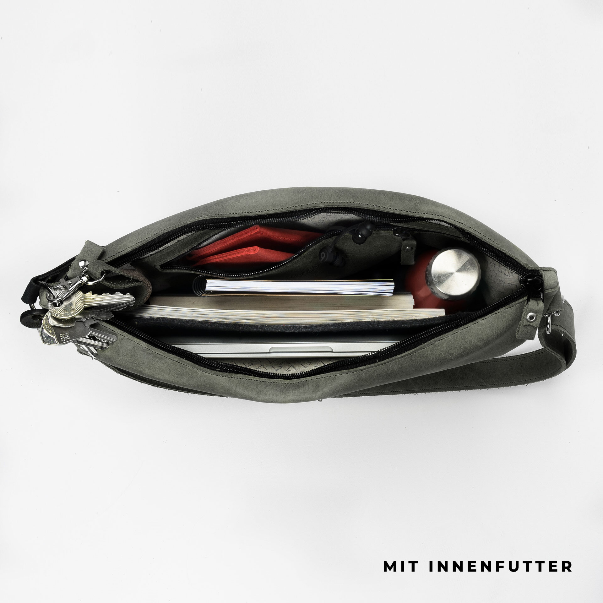 Ansicht von oben befüllte Umhängetasche ANA mit Schultergurt aus steingrauem Naturleder