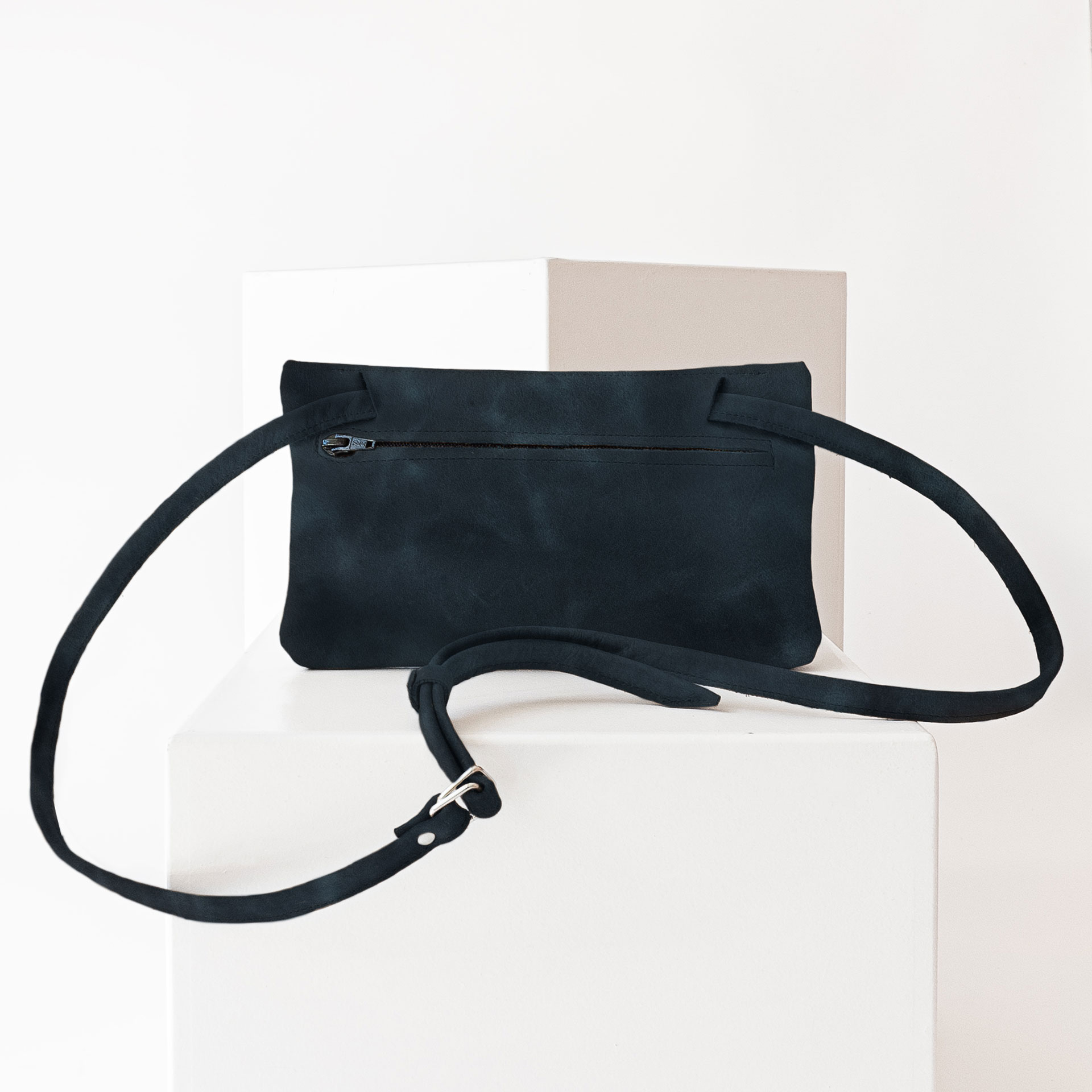 Rückseite der Umhängetasche ISA aus Naturleder in Dunkelblau mit verstellbarem Träger