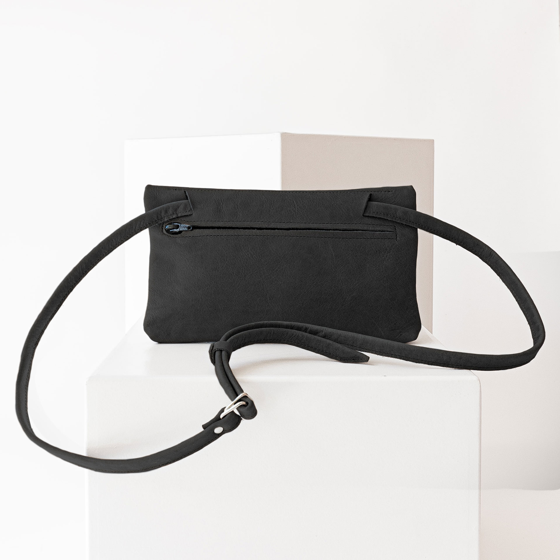 Rückseite der Umhängetasche ISA aus Naturleder in Kohle mit verstellbarem Träger