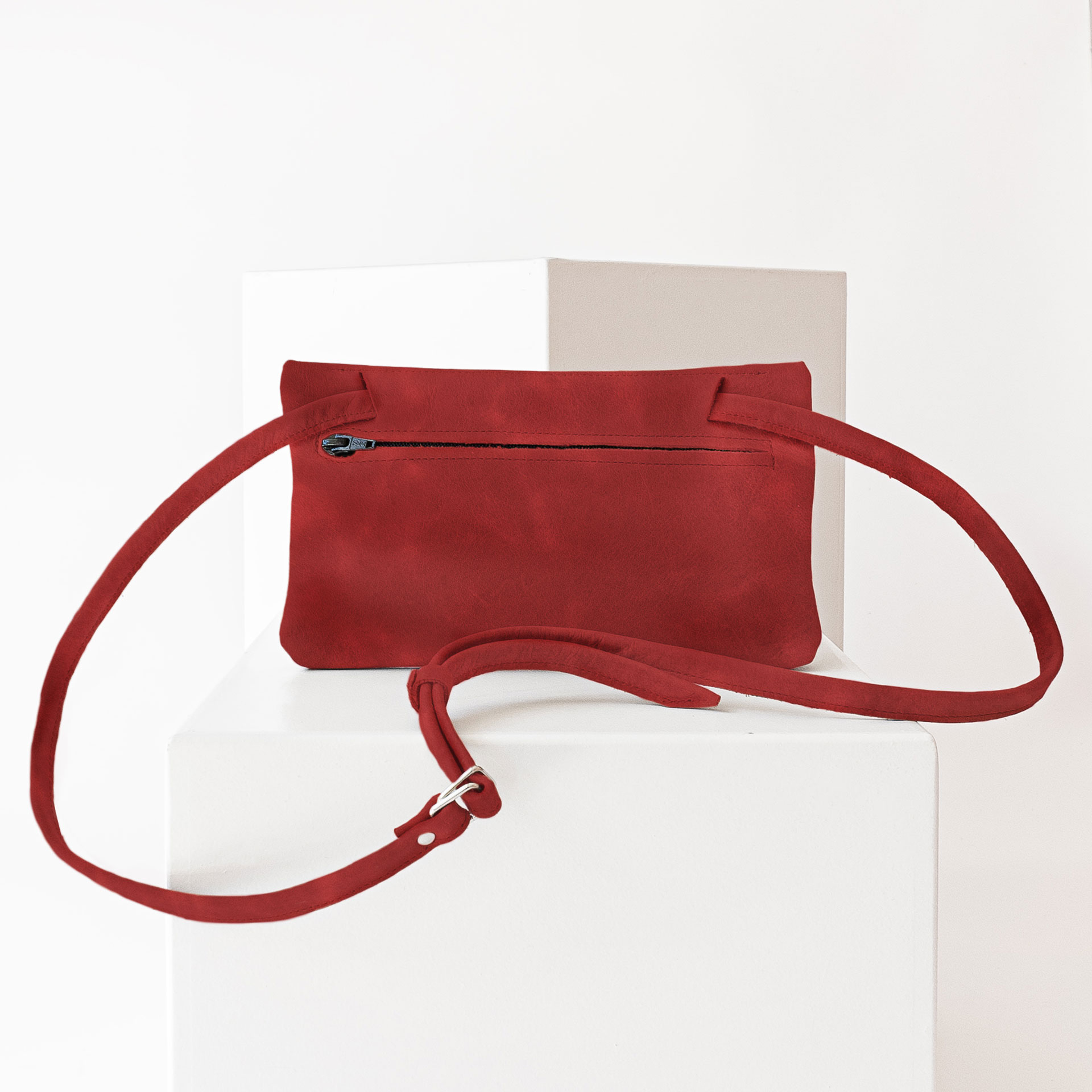 Rückseite der Umhängetasche ISA aus Naturleder in Rot mit verstellbarem Träger