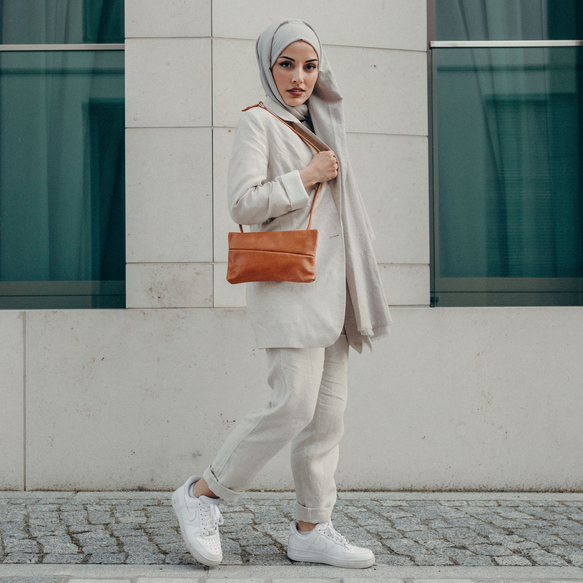 Model trägt 3-in-1 Tasche Isa in der Farbe Cognac geölt aus Naturleder über der Schulter.