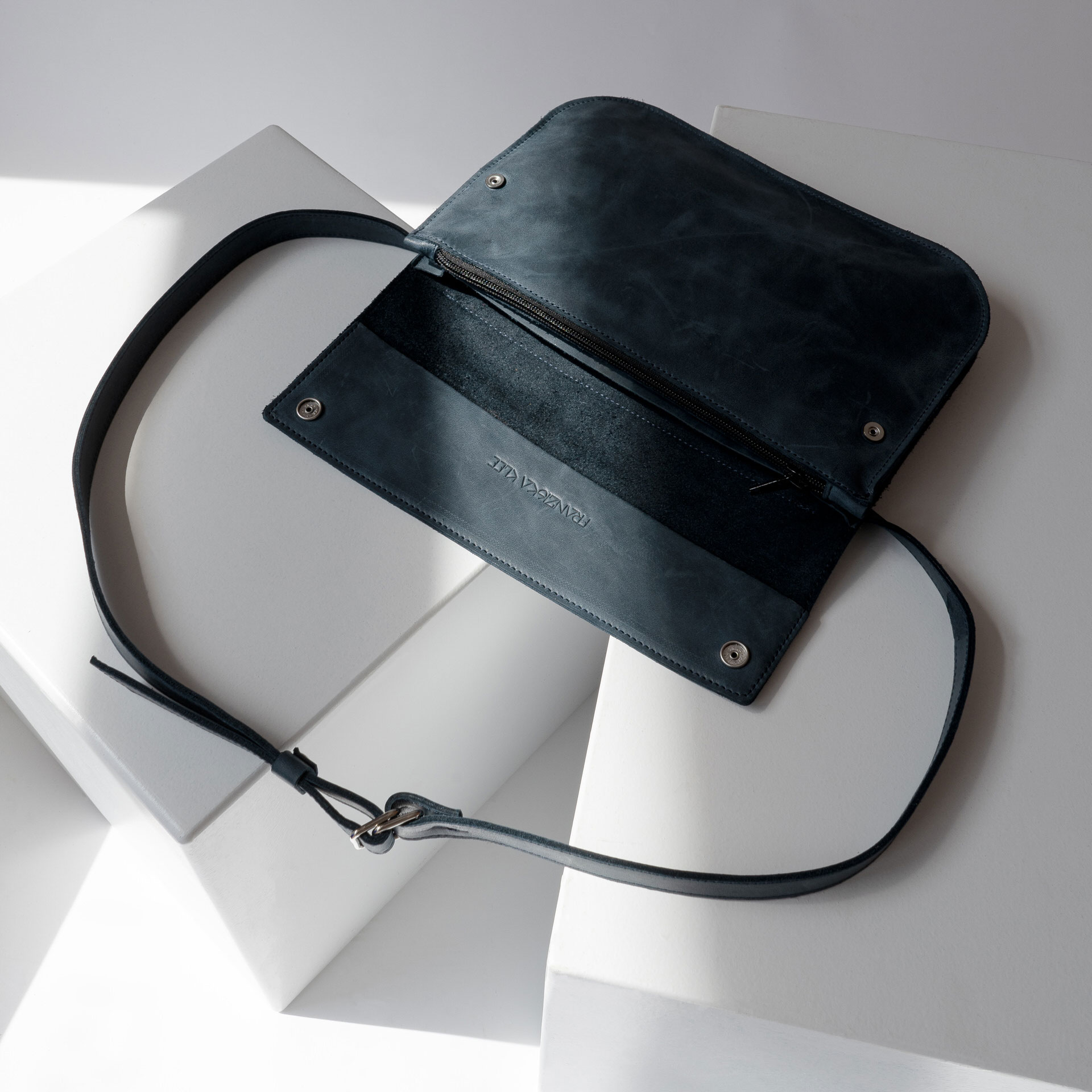 Crossbody Bag TEA Large liegt aufgeklappt auf einem Tisch.