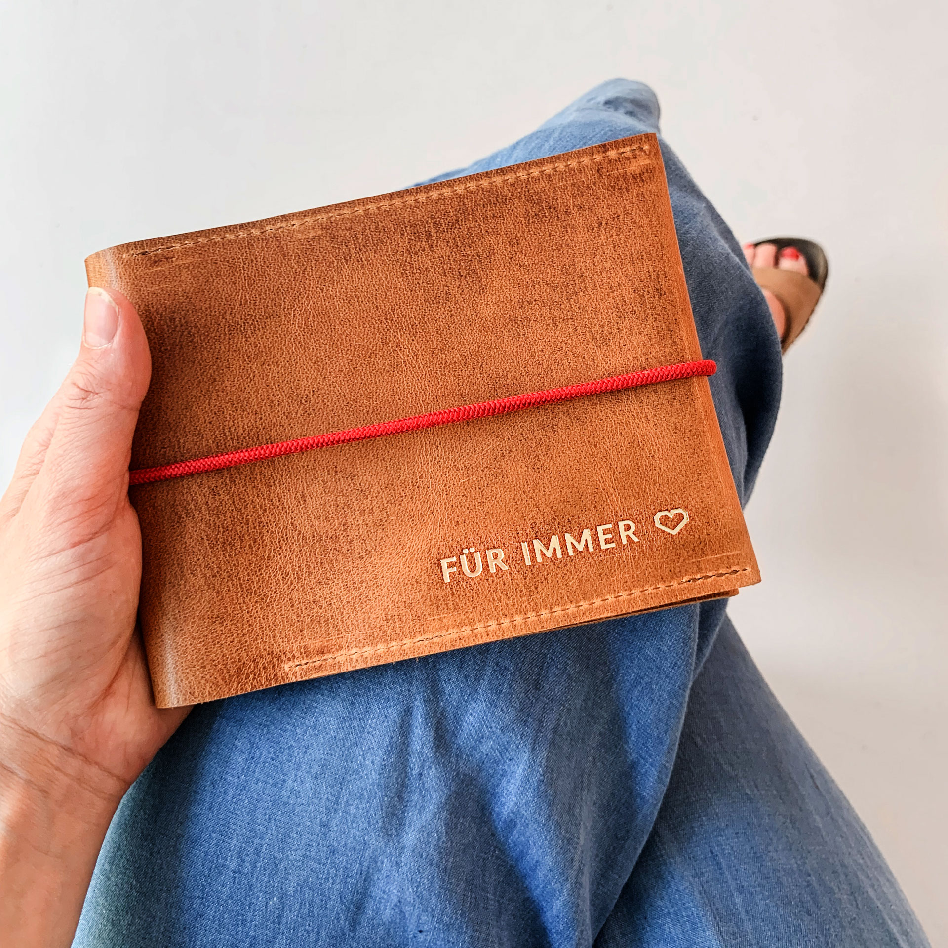 Mood Shot Familienreisepasshülle EVE aus nachhaltigem Naturleder in Cognac geölt mit rotem Verschlussband und individueller Prägung in Gold