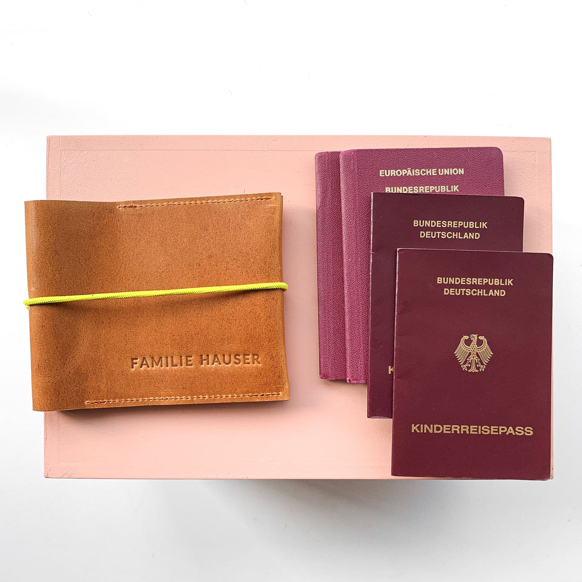 Familienreisepasshülle EVE aus nachhaltigem Naturleder in Cognac geölt mit gelbem Verschlussband und individueller Prägung