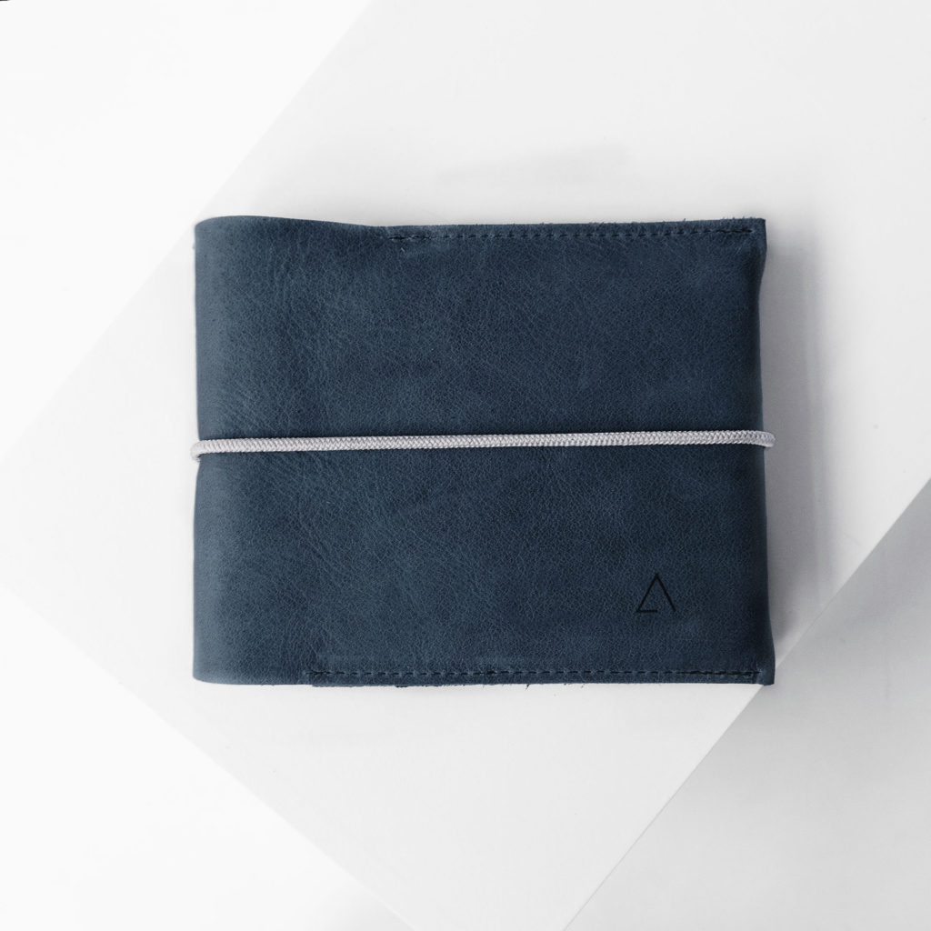 Familienreisepasshülle EVE aus nachhaltigem Naturleder in Dunkelblau mit cremefarbenem Verschlussband und dezenter Logoprägung