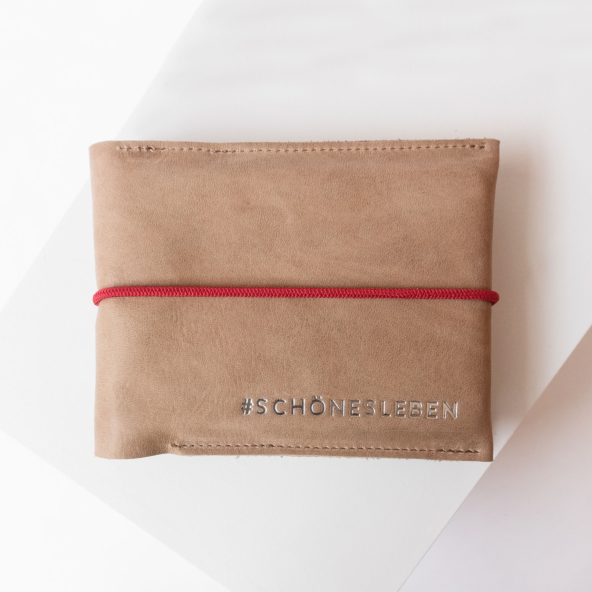 Familienreisepasshülle EVE aus nachhaltigem Naturleder in Hellbraun mit rotem Verschlussband und individueller Prägung in Silber