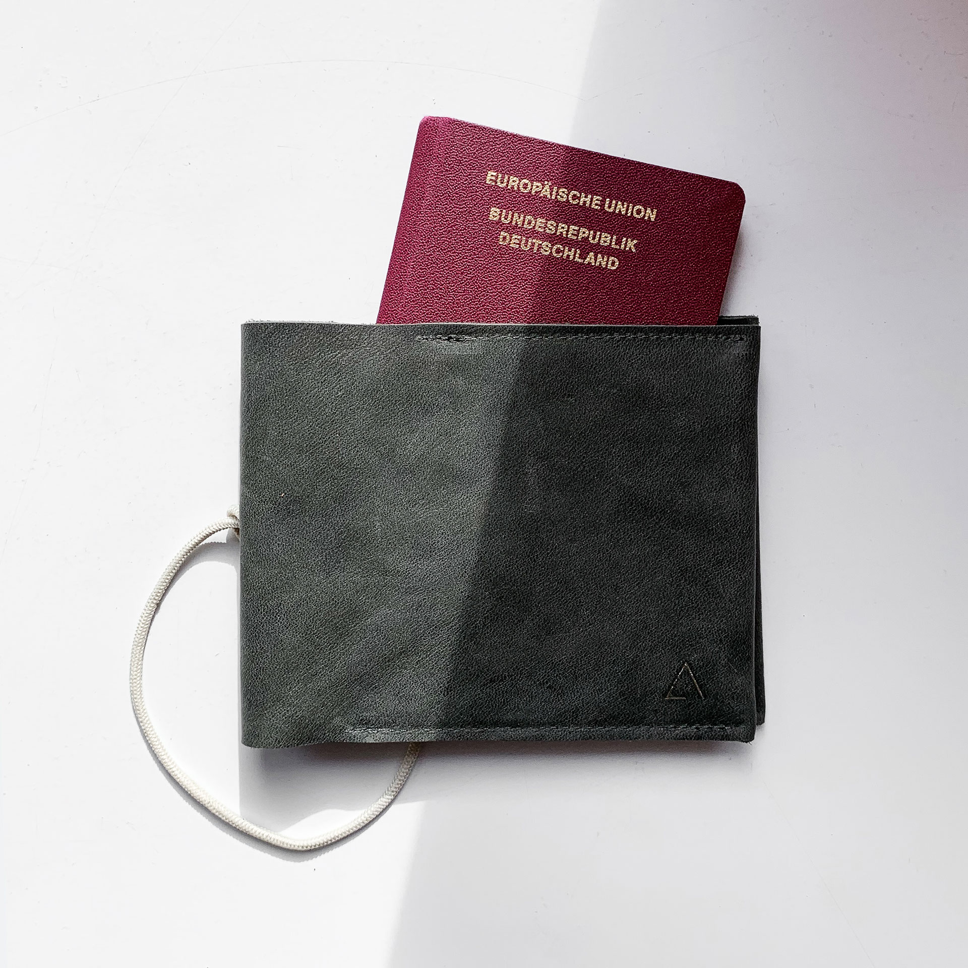Mood Shot Familienreisepasshülle EVE aus nachhaltigem Naturleder in Steingrau mit cremefarbenem Verschlussband und schlichter Logoprägung