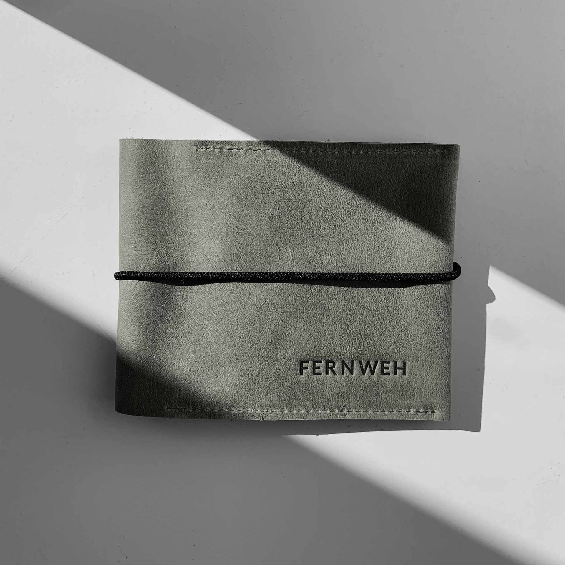 Familienreisepasshülle EVE aus nachhaltigem Naturleder in Steingrau mit schwarzem Verschlussband und individueller Prägung