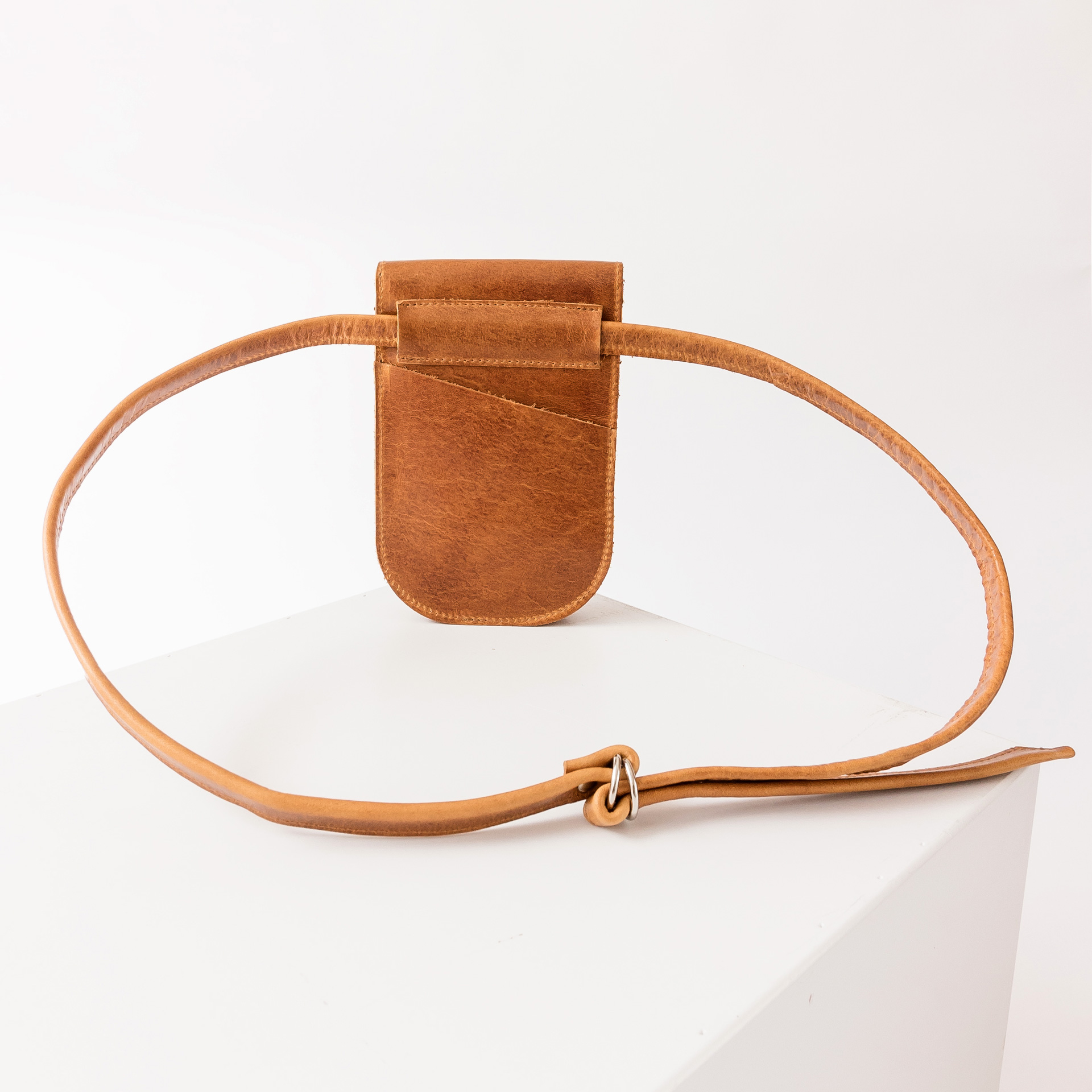 Rückseite der Handytasche IRA aus nachhaltigem Naturleder in Cognac geölt mit langem Träger und kleinem Steckfach