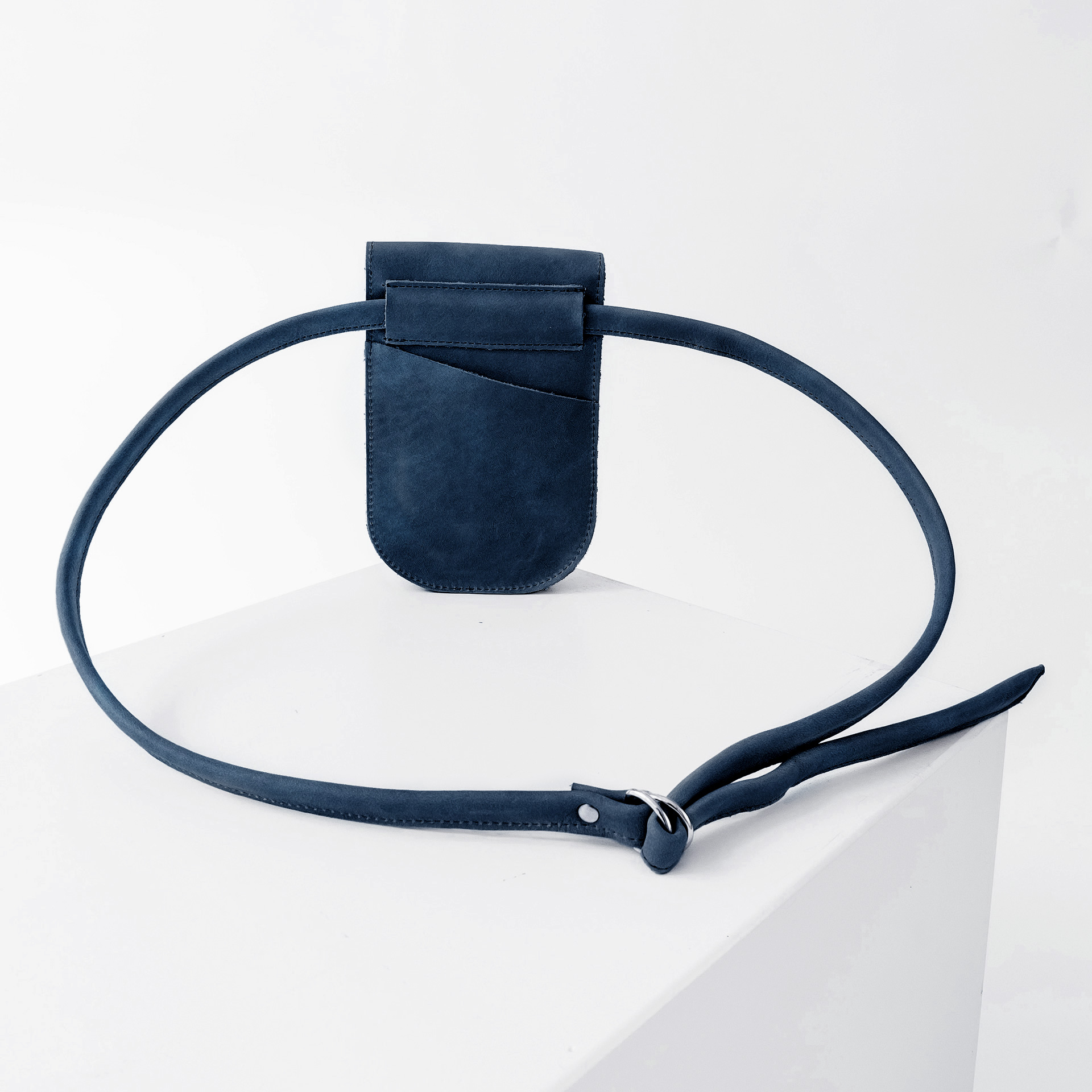 Rückseite der Handytasche IRA aus nachhaltigem Naturleder in Dunkelblau mit langem Träger und kleinem Steckfach