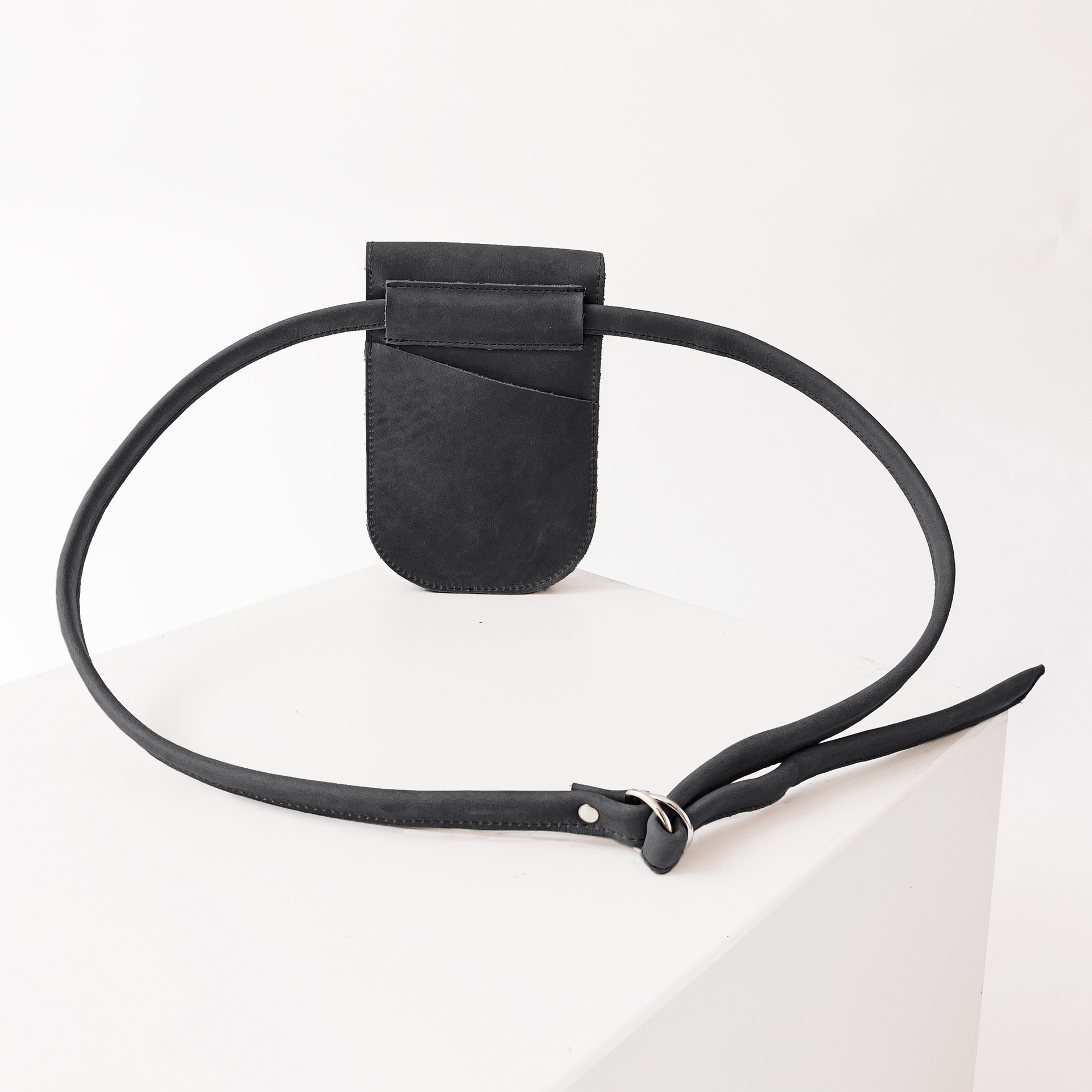 Rückseite der Handytasche IRA aus nachhaltigem Naturleder in Kohle mit langem Träger und kleinem Steckfach