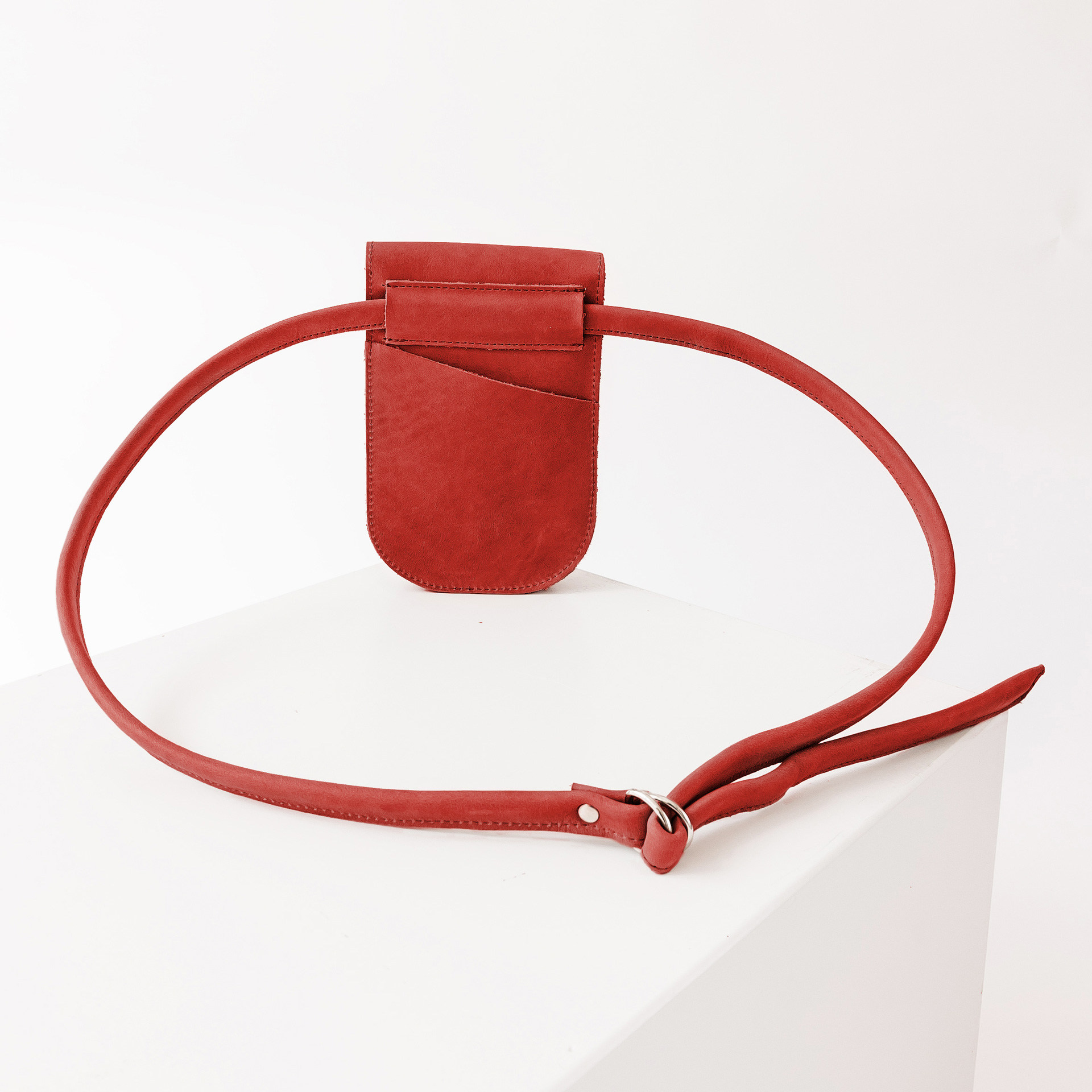 Rückseite der Handytasche IRA aus nachhaltigem Naturleder in Rot mit langem Träger und kleinem Steckfach