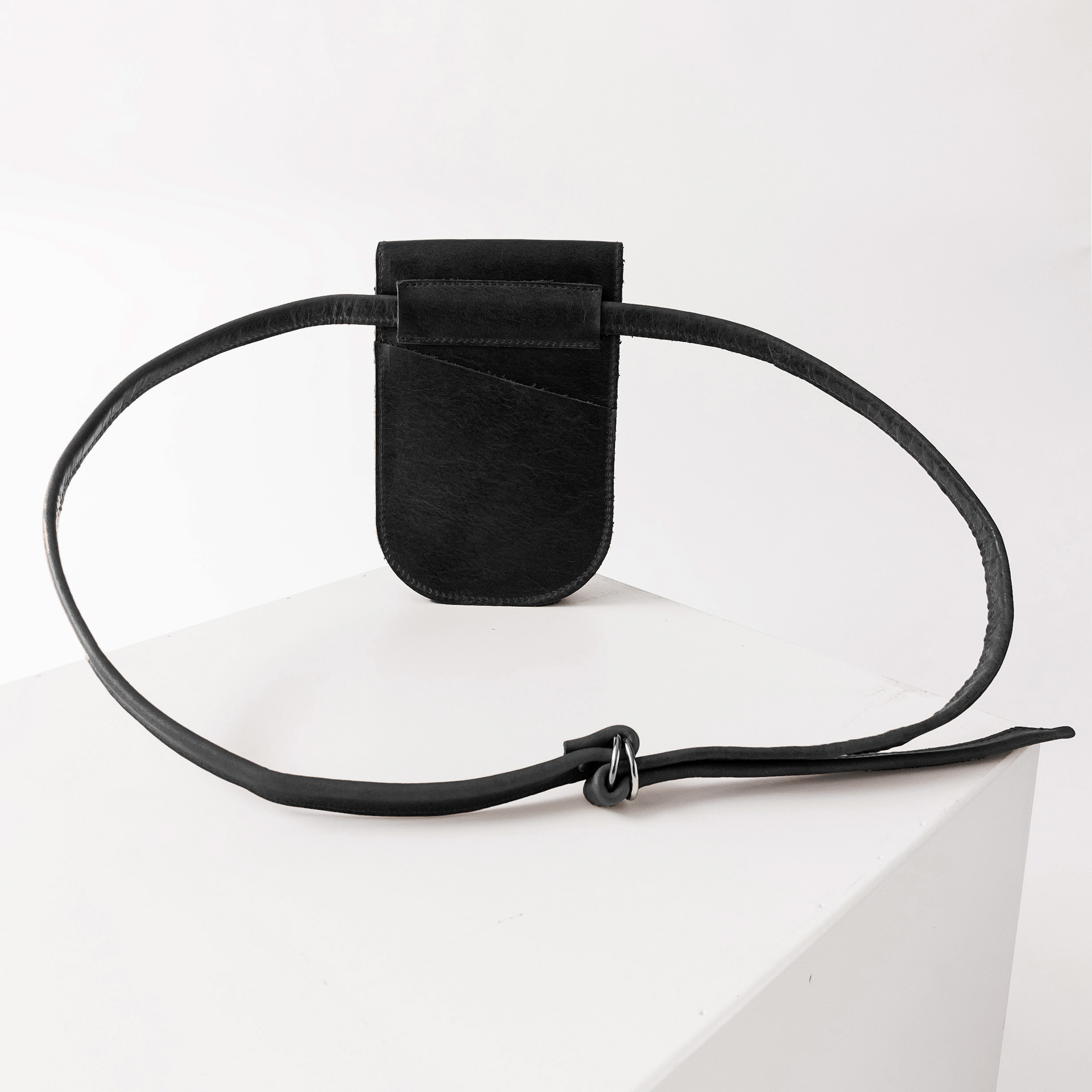 Rückseite der Handytasche IRA aus nachhaltigem Naturleder in Schwarz geölt mit langem Träger und kleinem Steckfach