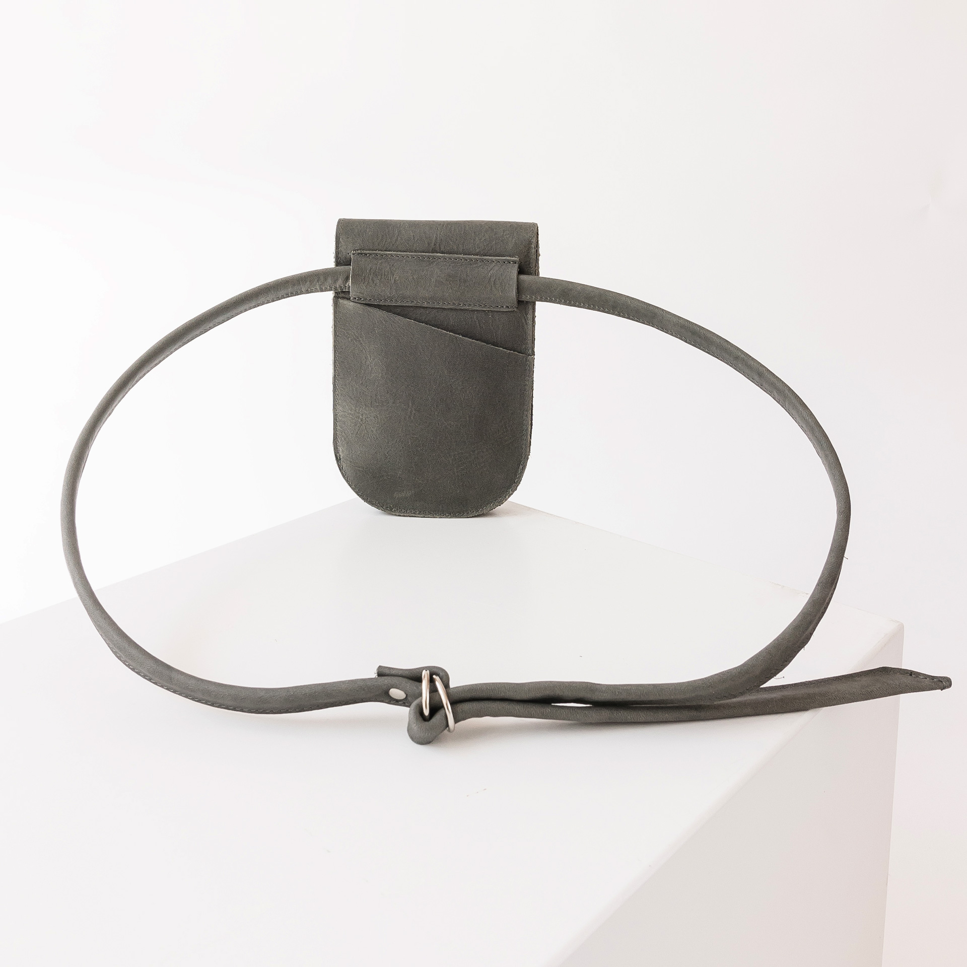 Rückseite der Handytasche IRA aus nachhaltigem Naturleder in Steingrau mit langem Träger und kleinem Steckfach