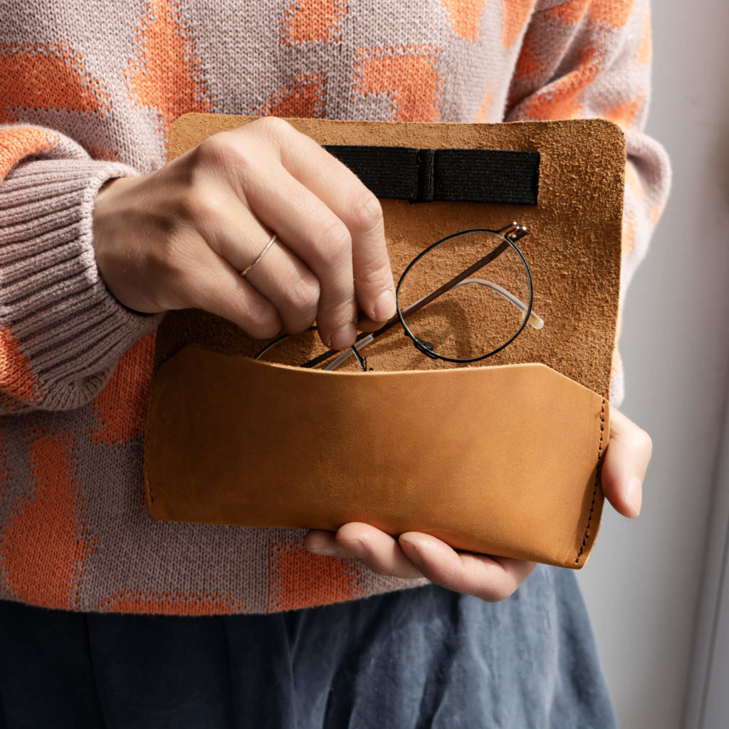 Frau legt Brille in Brillenetui LUK aus nachhaltigem Naturleder in Cognac