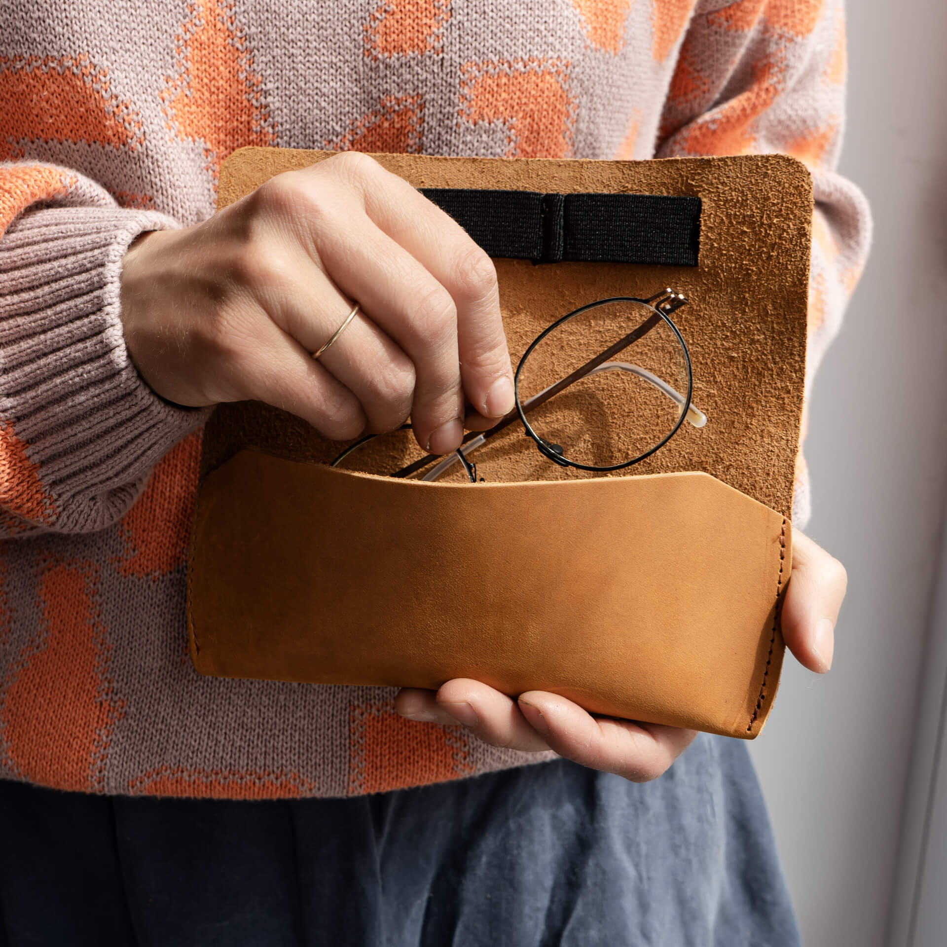 Frau legt Brille in Brillenetui LUK aus nachhaltigem Naturleder in Cognac