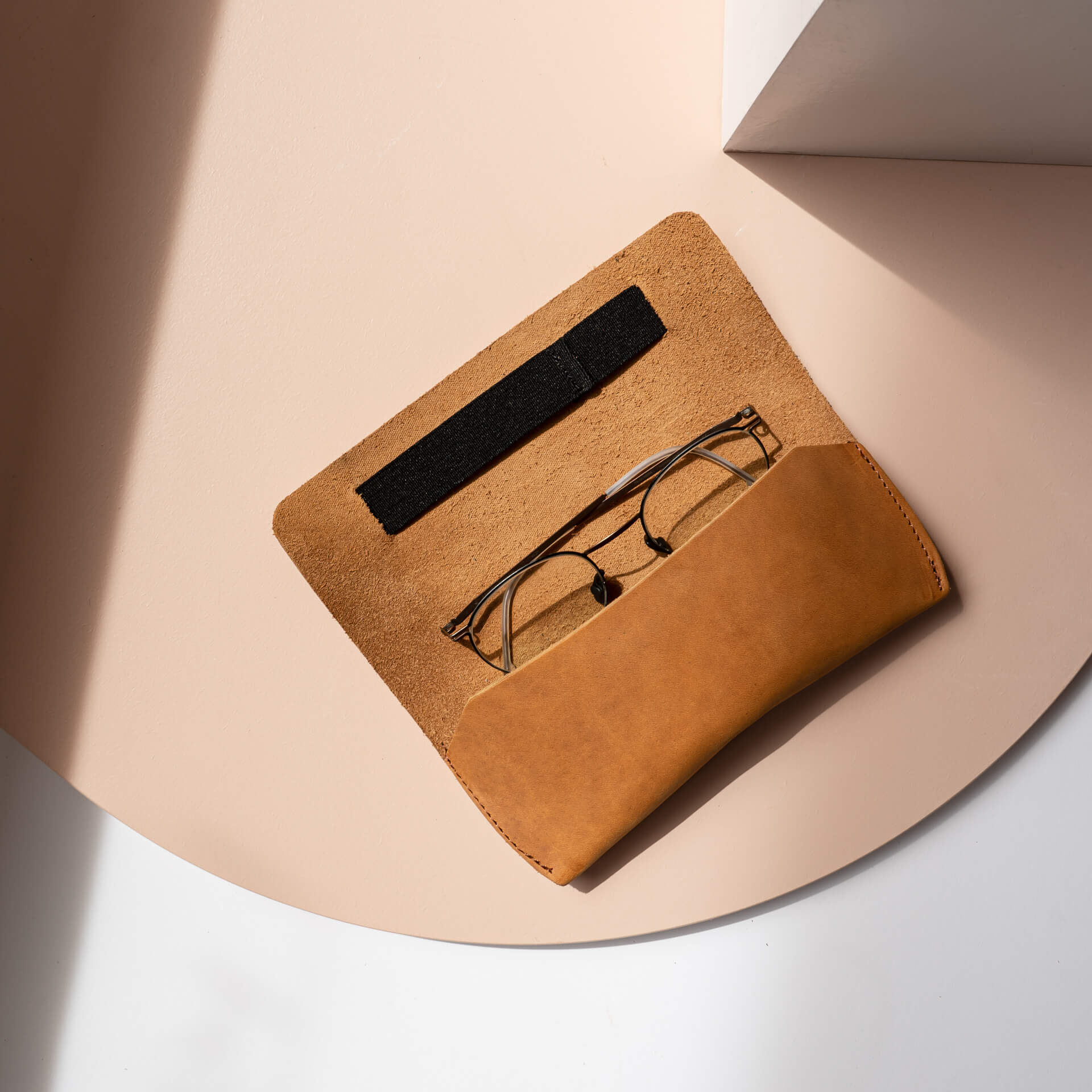 Brillenetui LUK aus nachhaltigem Naturleder in Cognac mit schwarzem Verschlussband aufgeklappt mit Brille