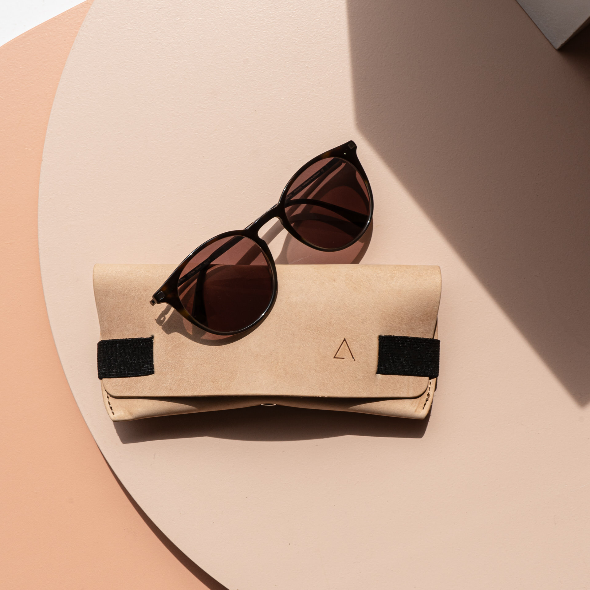 Brillenetui LUK in Hellbraun mit schwarzem Verschlussband von vorn mit Sonnenbrille