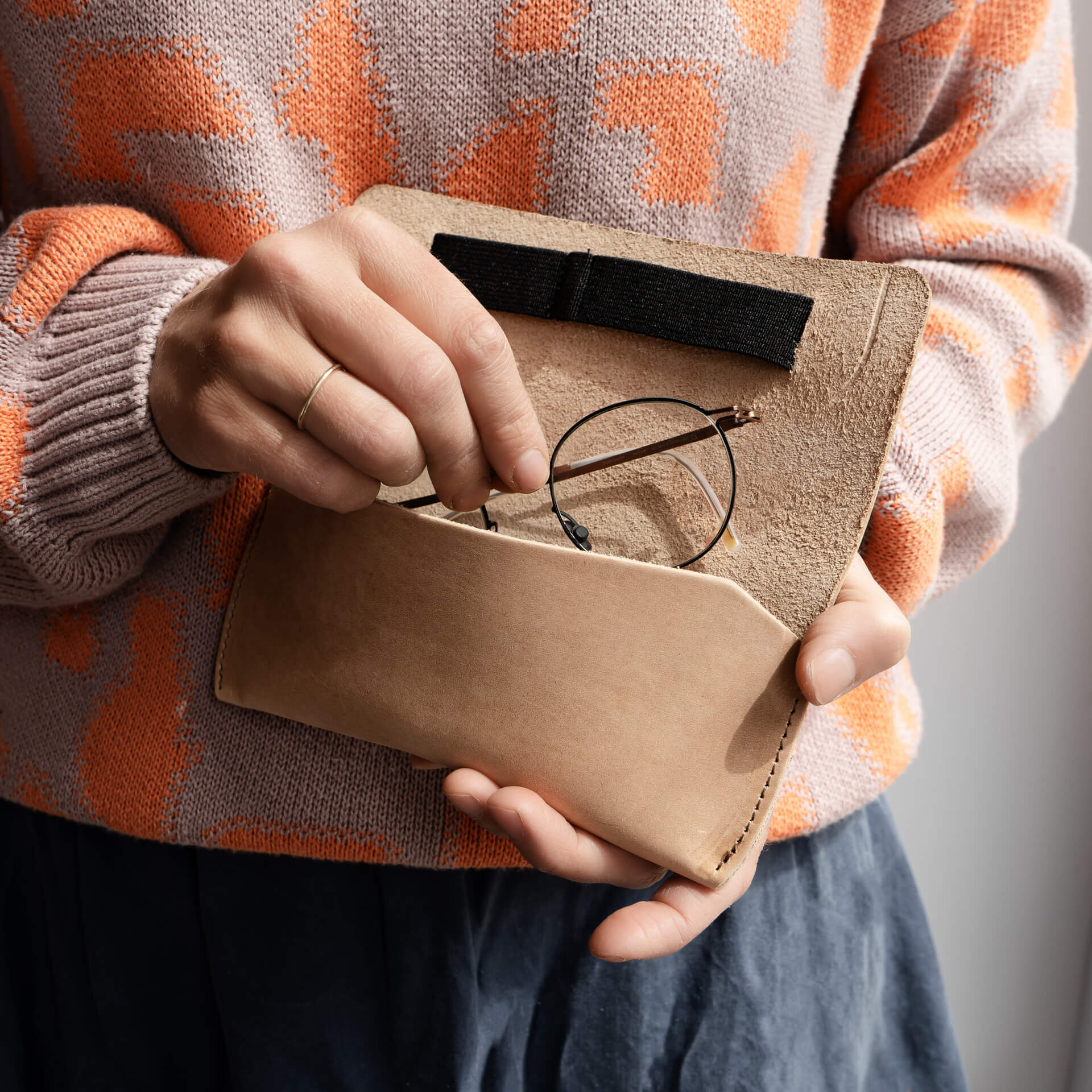 Frau legt Brille in Brillenetui LUK aus nachhaltigem Naturleder in Hellbraun