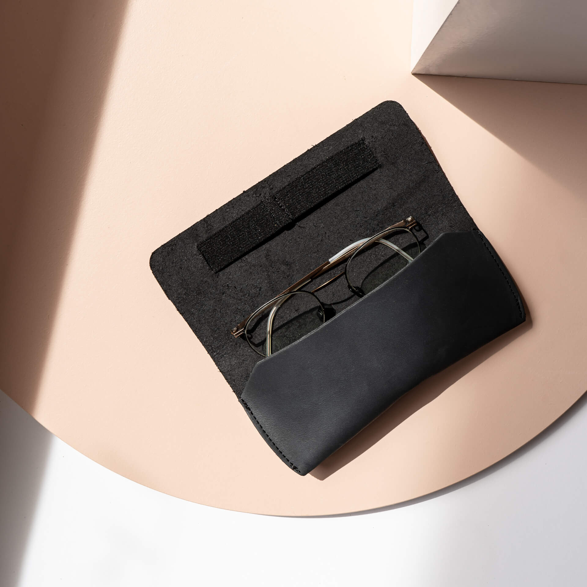 Brillenetui LUK aus nachhaltigem Naturleder in Kohle mit schwarzem Verschlussband aufgeklappt mit Brille