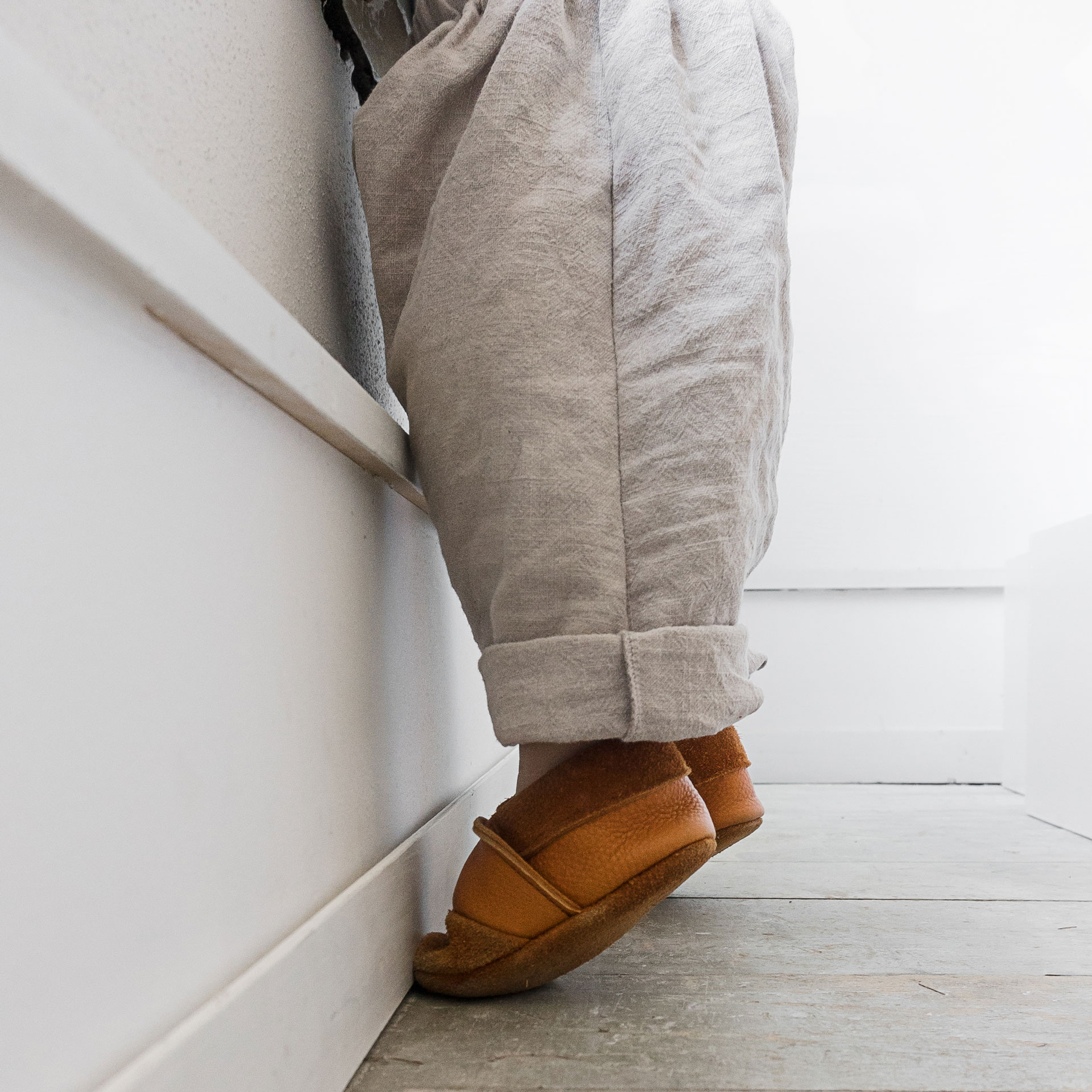 Kind trägt Lauflernschuhe in der Farbe Cognac.