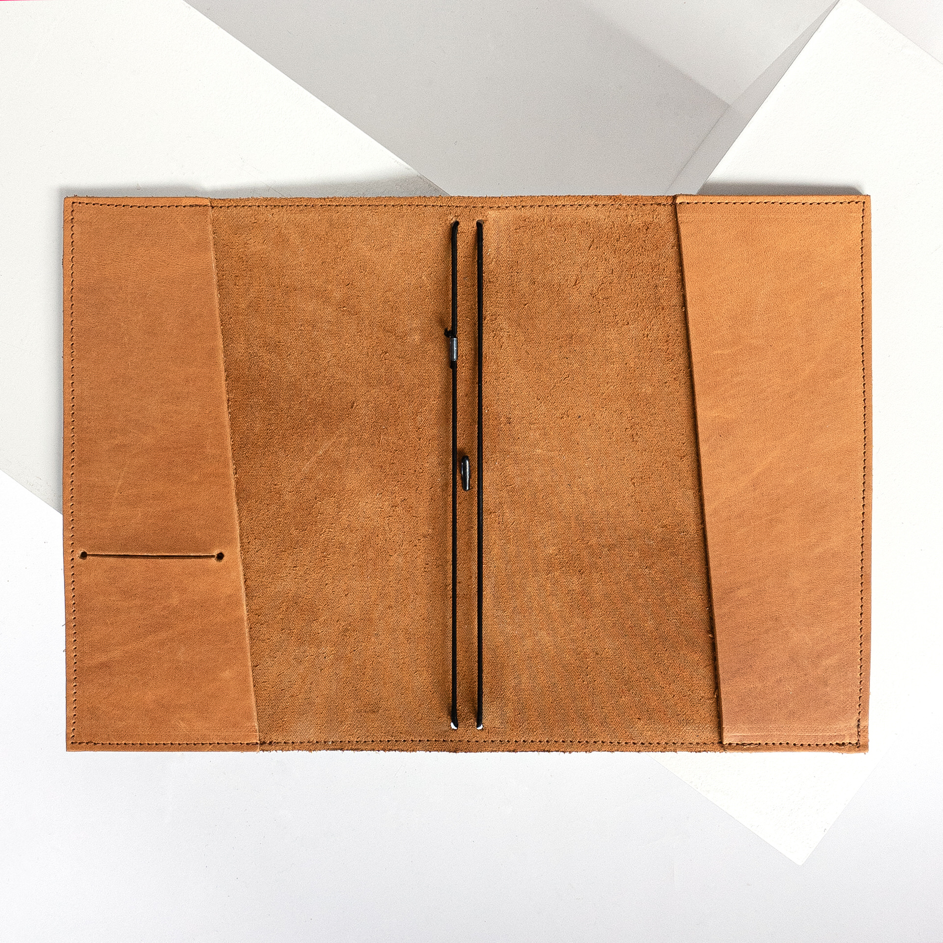 Notizbuchhülle NOA A5 in der Farbe Cognac liegt geöffnet auf dem Tisch.