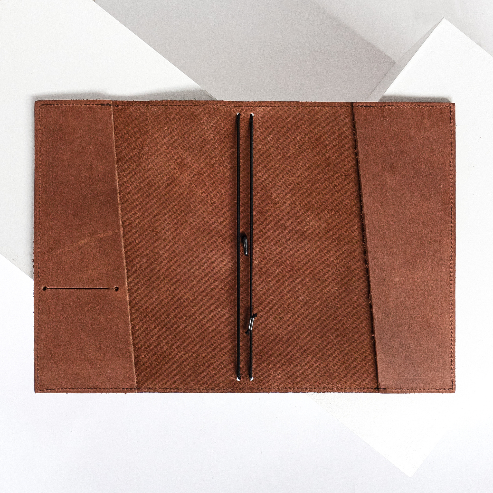 Notizbuchhülle NOA A5 in der Farbe Dunkelbraun liegt geöffnet auf dem Tisch.