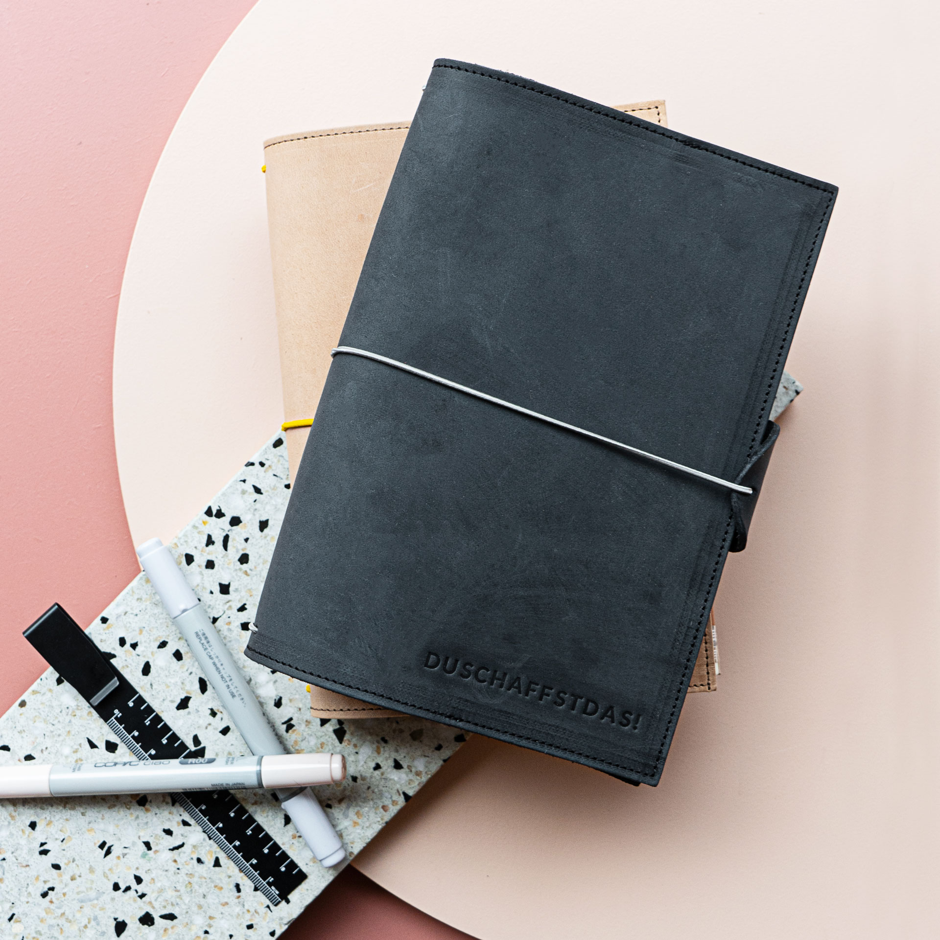 Notizbuchhüllen NOA A5 in der Farbe Kohle mit Prägung in Natur mit cremefarbenem Band.