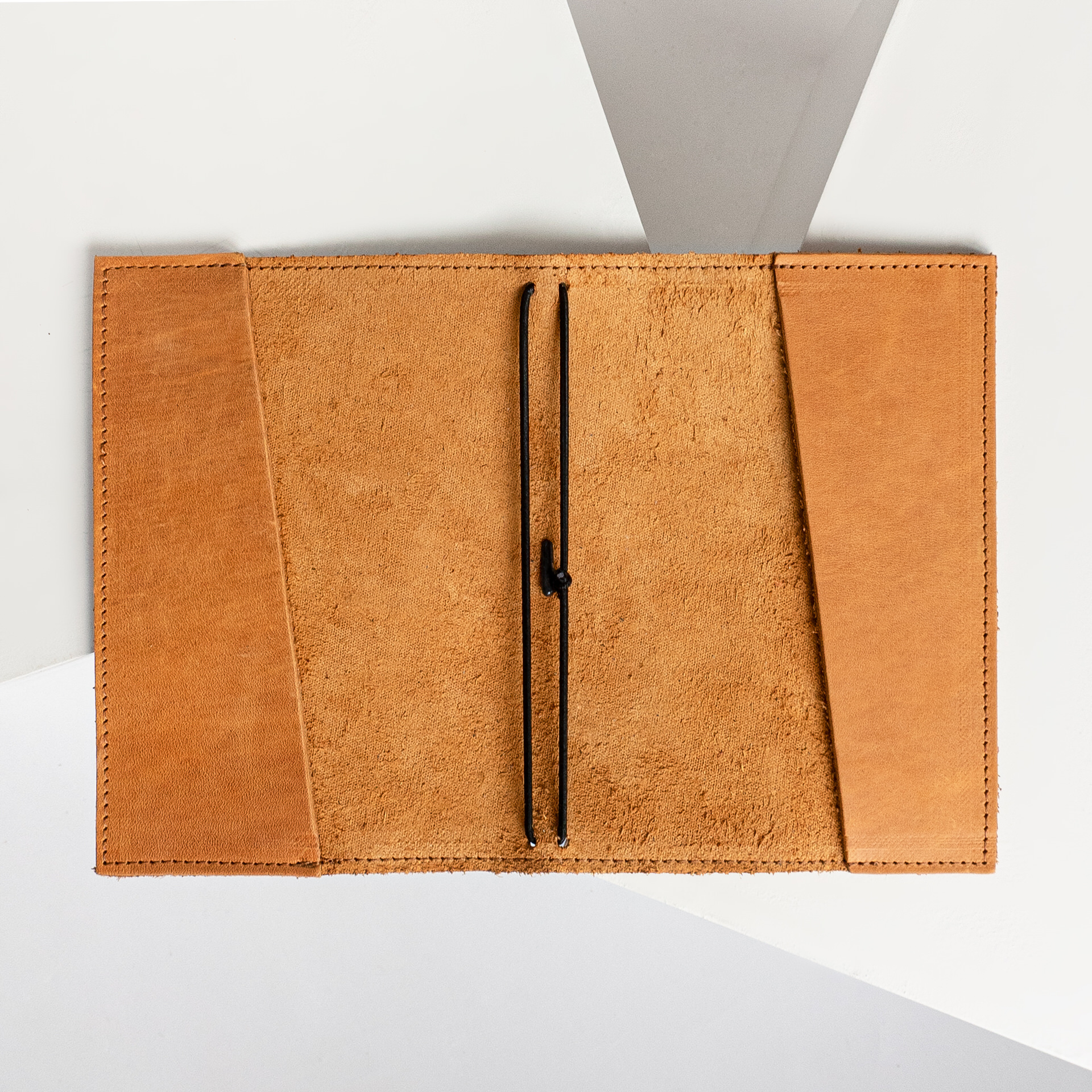 Notizbuchhülle NOA A6 in der Farbe Cognac liegt geöffnet auf dem Tisch.