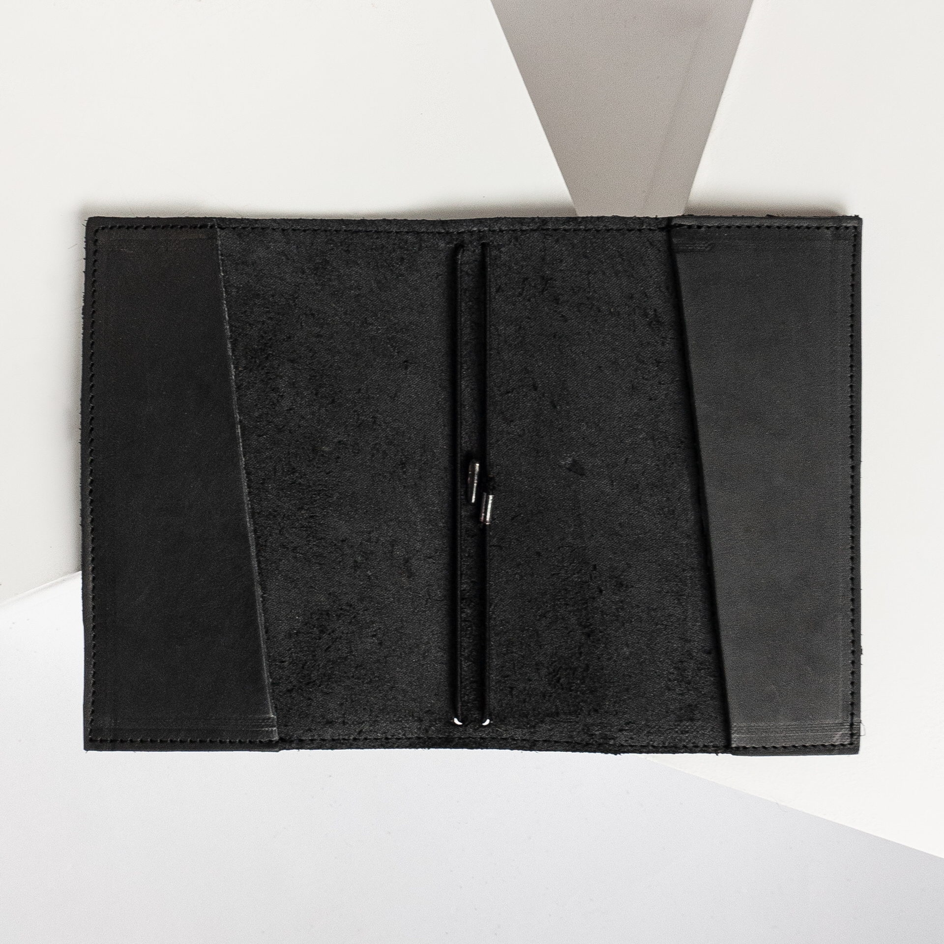 Notizbuchhülle NOA A6 in der Farbe Kohle liegt geöffnet auf dem Tisch.