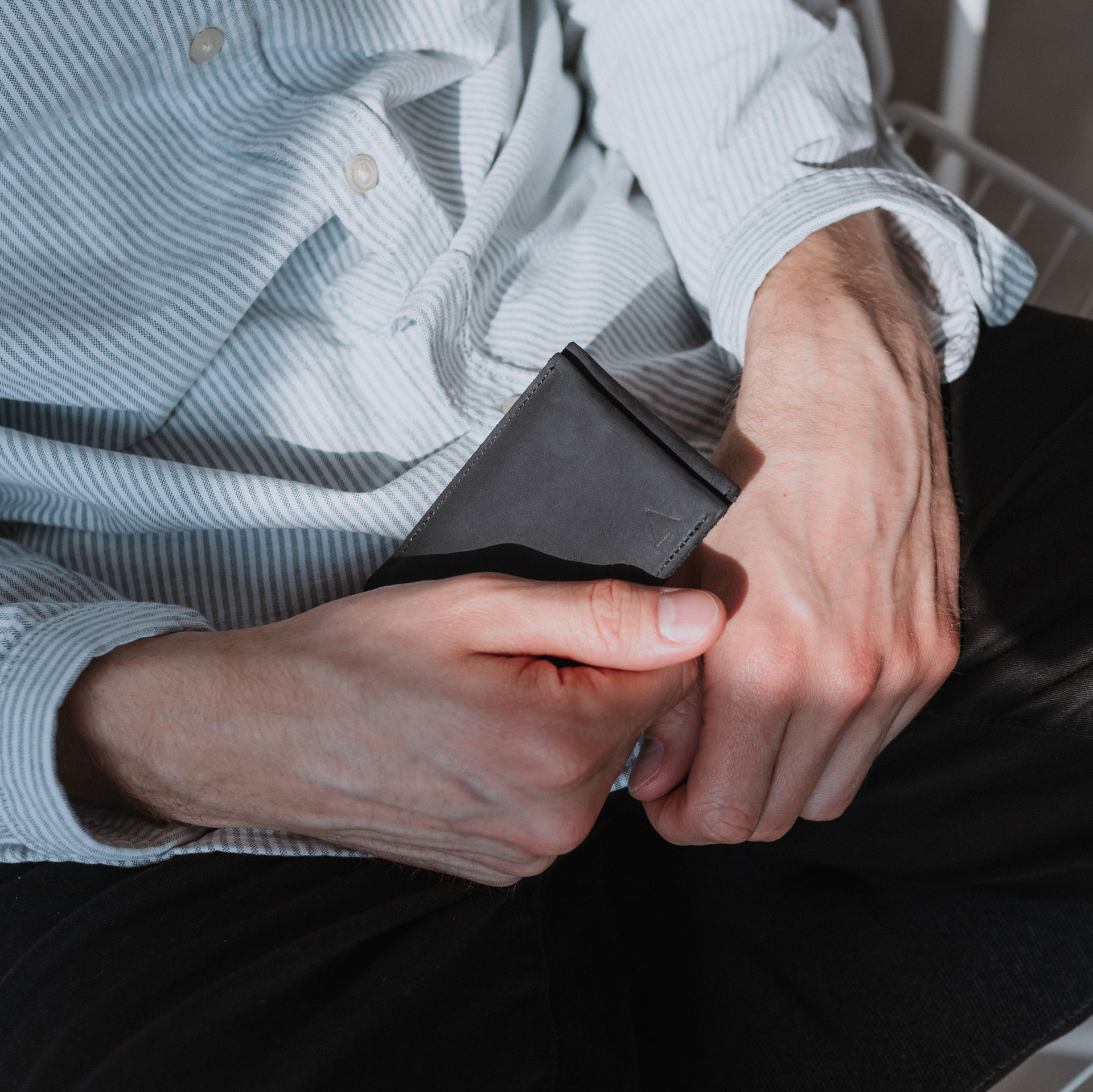 Model hält Portemonnaie Oli Small in Kohle aus nachhaltigem Naturleder