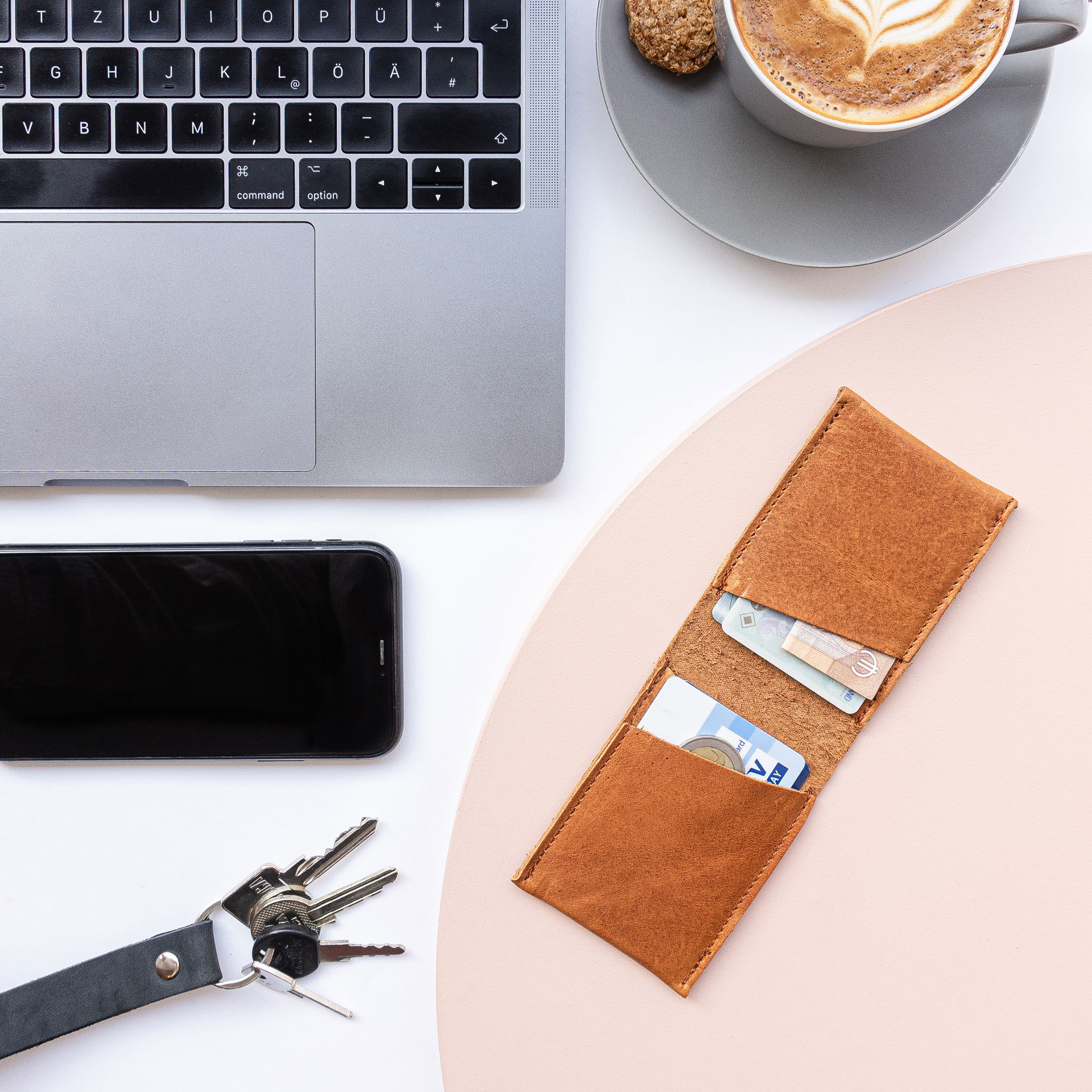 Portemonnaie OLI SMALL geöffnet in Cognac geölt mit Laptop, Kaffeetasse, Handy und Schlüssel