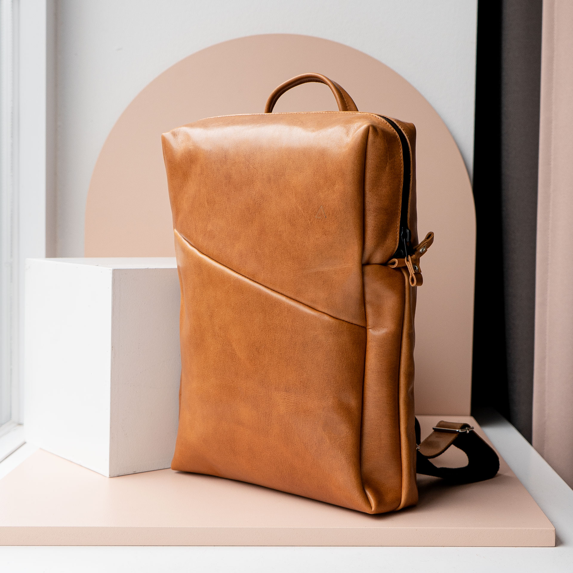 Mood Shot seitlich des Rucksacks NEO LARGE aus nachhaltigem Naturleder in Cognac geölt mit extra weiter Öffnung