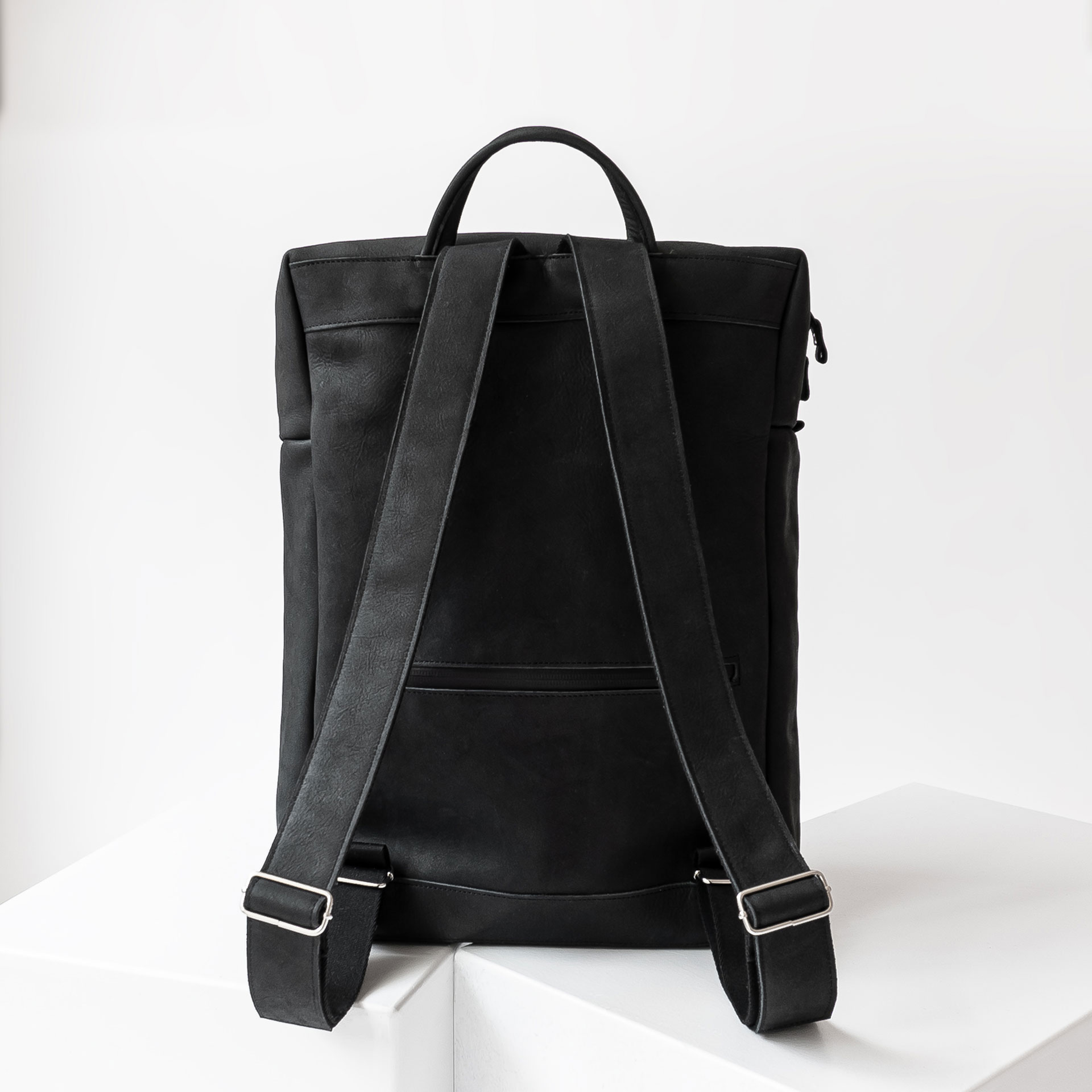 Rückseite des Rucksacks NEO LARGE aus Naturleder in Kohle mit verstellbaren Trägern und Extrafach