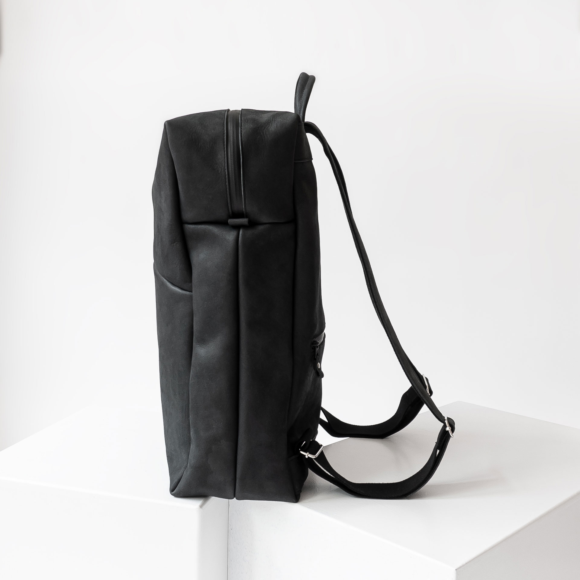 Seitenansicht des Rucksacks NEO LARGE aus Naturleder in Kohle