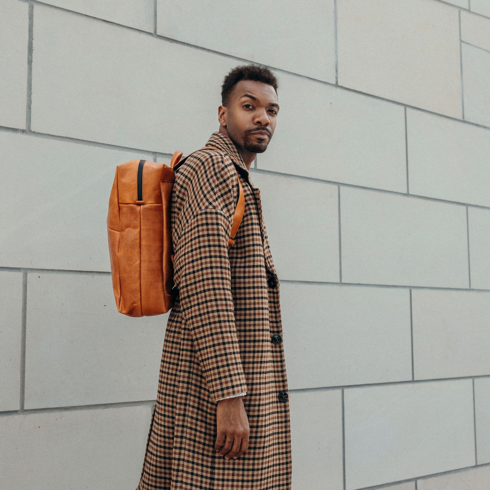 Model mit Rucksack Neo Large aus cognac geöltem Naturleder
