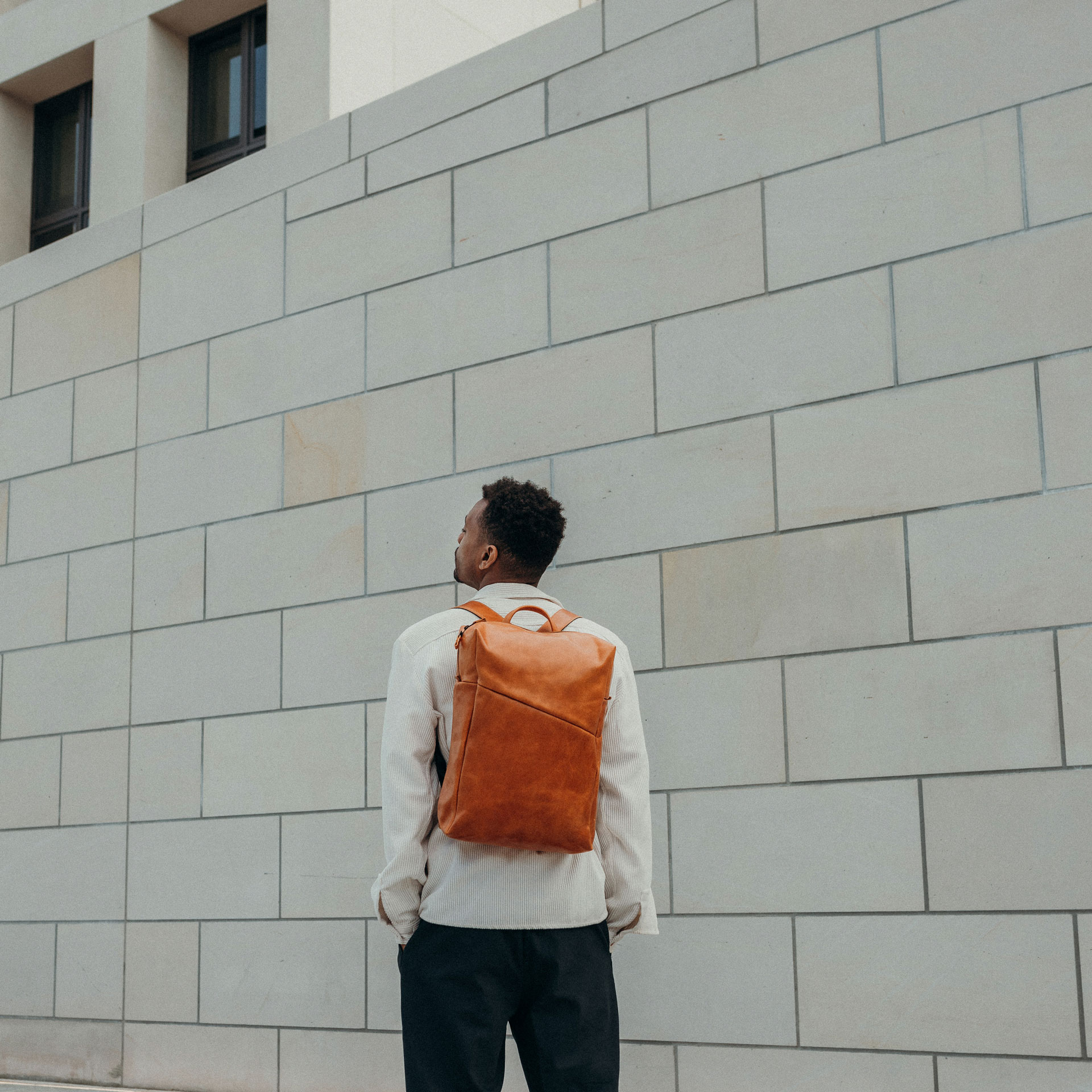 Unser Model Mack in den Häuserschluchten einer Stadt - auf dem Rücken trägt er unseren Daypack NEO Large.