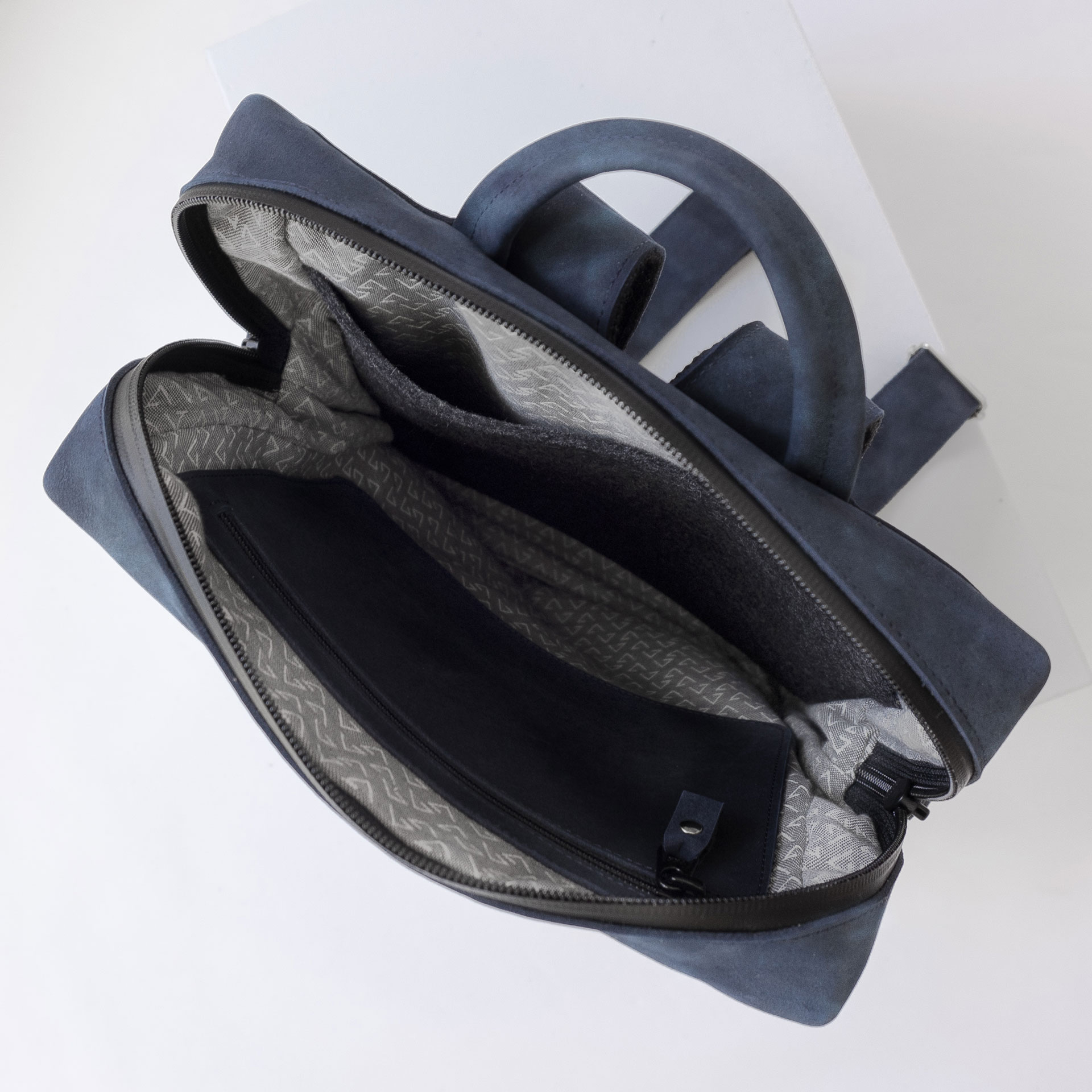 Innenansicht des Rucksacks NEO SMALL aus Naturleder in Dunkelblau mit Futterstoff, Reißverschlusstasche und Laptopfach aus Filz