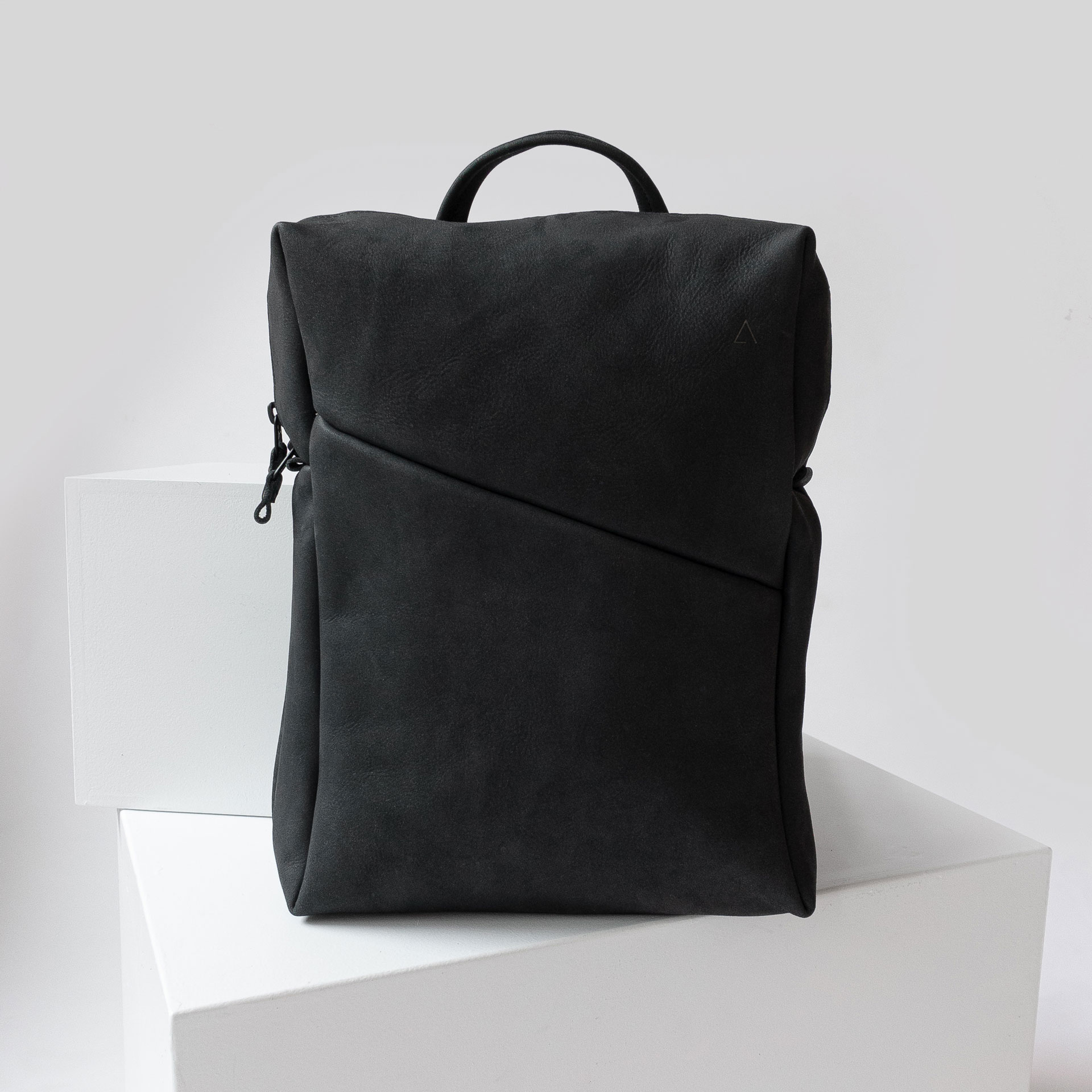 Vorderseite des Rucksacks NEO SMALL aus nachhaltigem Naturleder in Kohle in schlichtem Design