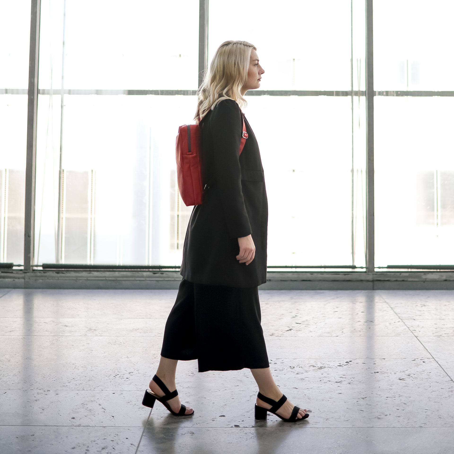 Model trägt Rucksack NEO small in der Farbe Rot.