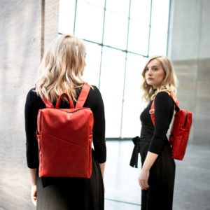 Model trägt Rucksack NEO small in der Farbe Rot.