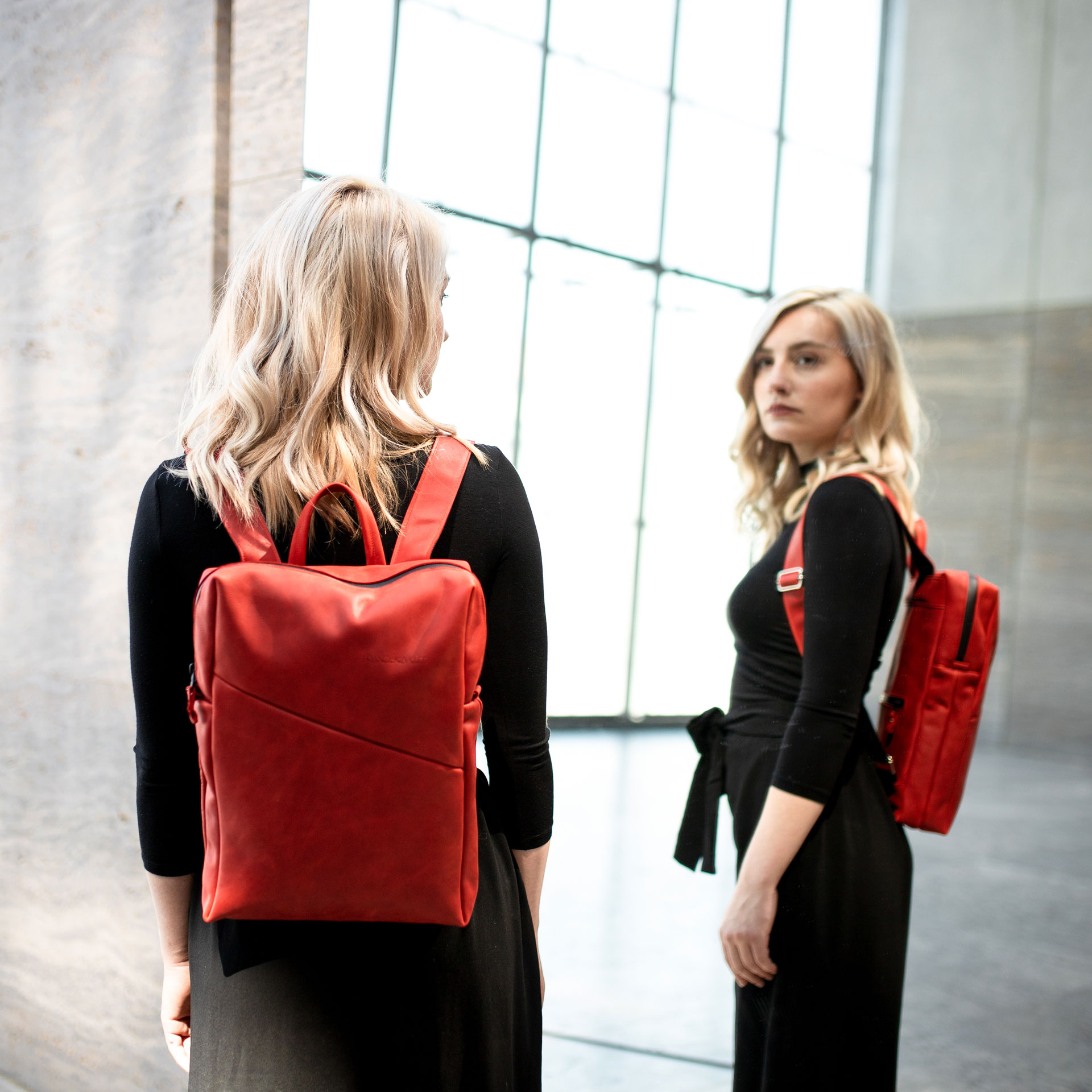 Model trägt Rucksack NEO small in der Farbe Rot.