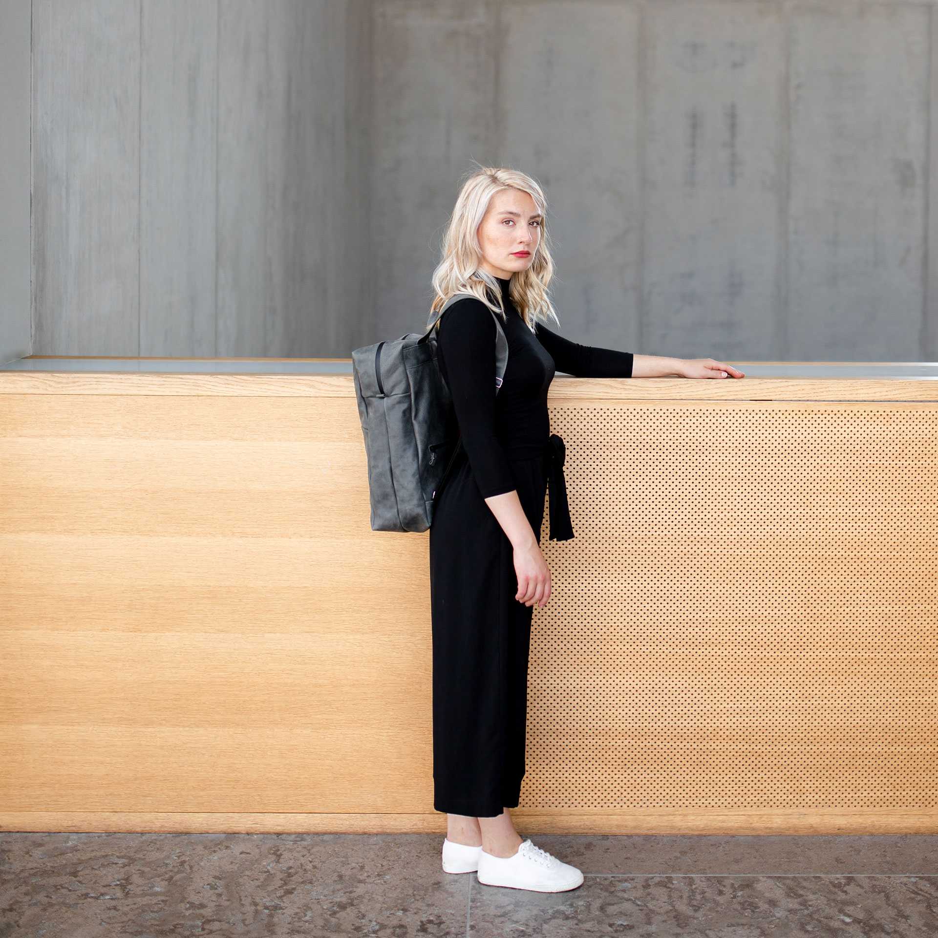 Model trägt den Rucksack NEO Large in der Farbe Steingrau.