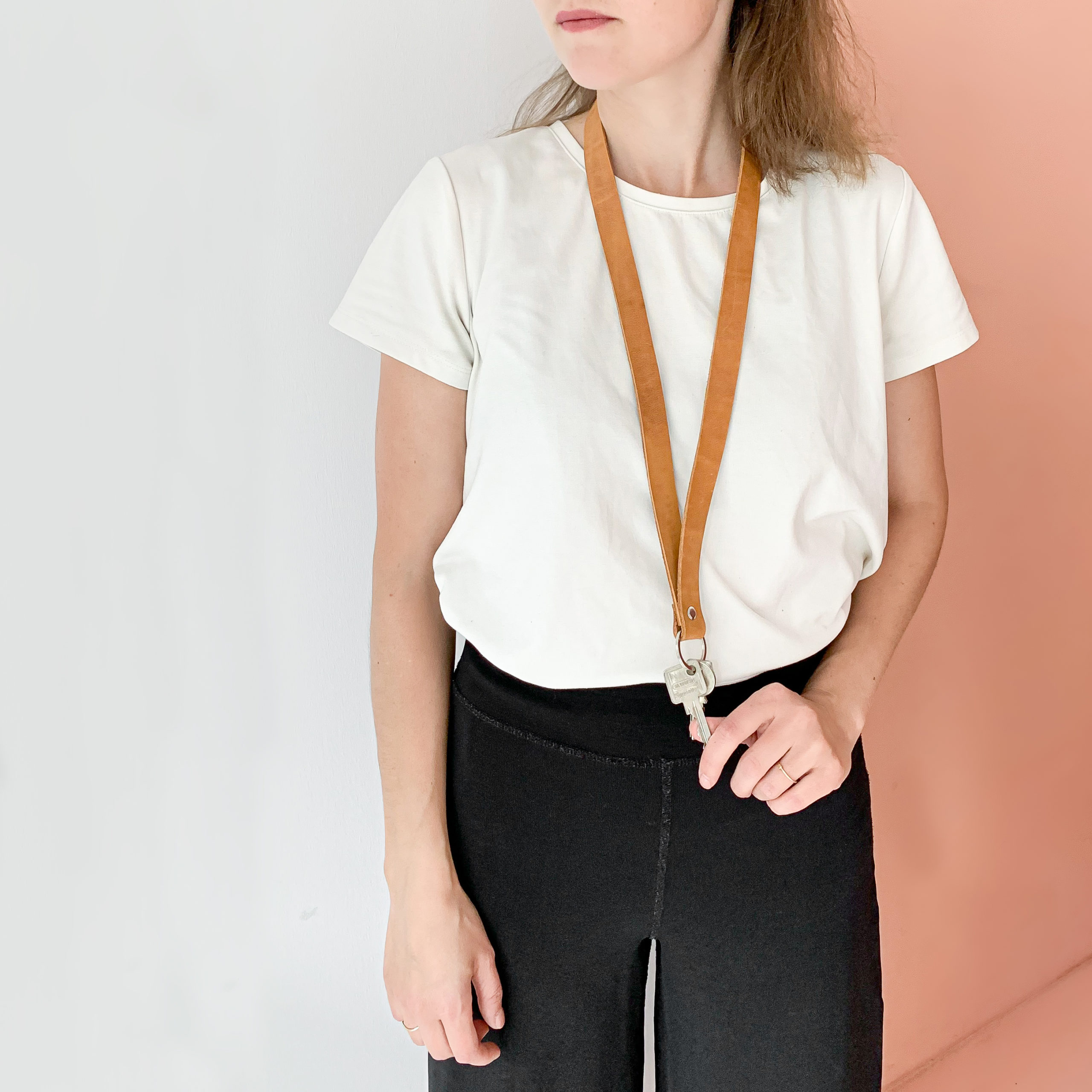 Schlüsselband LOC Large in der Farbe Cognac um den Hals getragen.