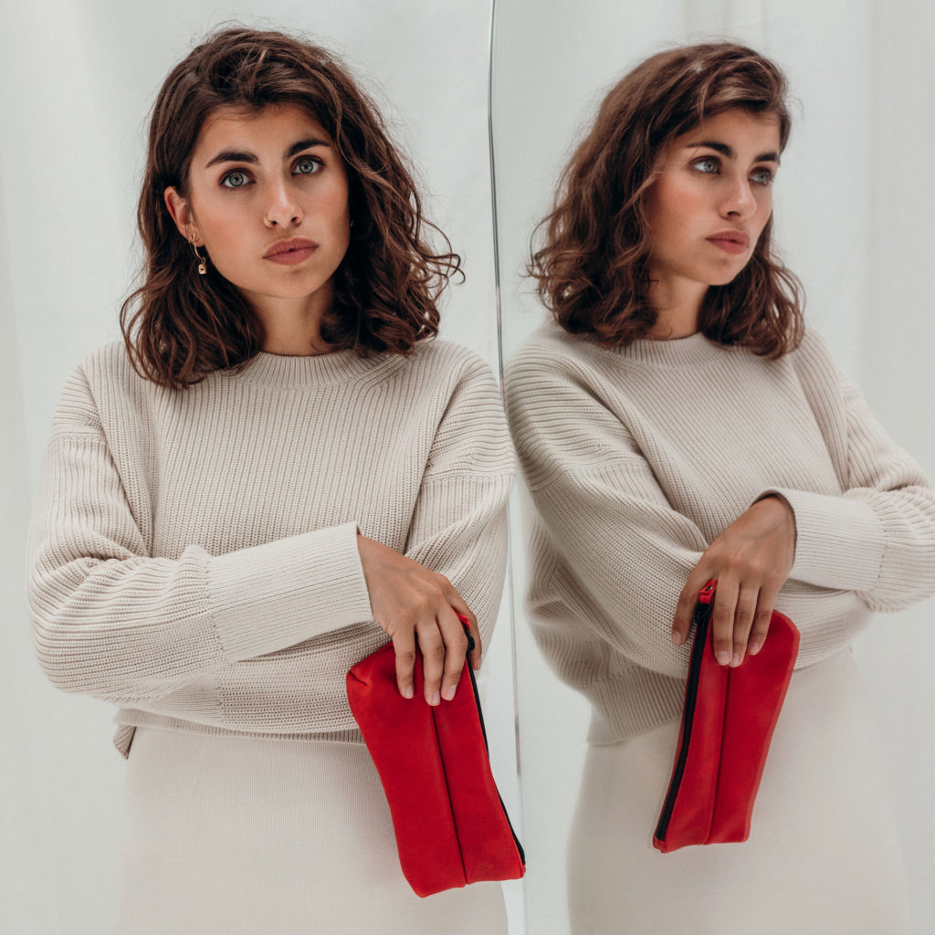 Model hält Stifteetui PEN Large aus nachhaltigem Naturleder in Rot