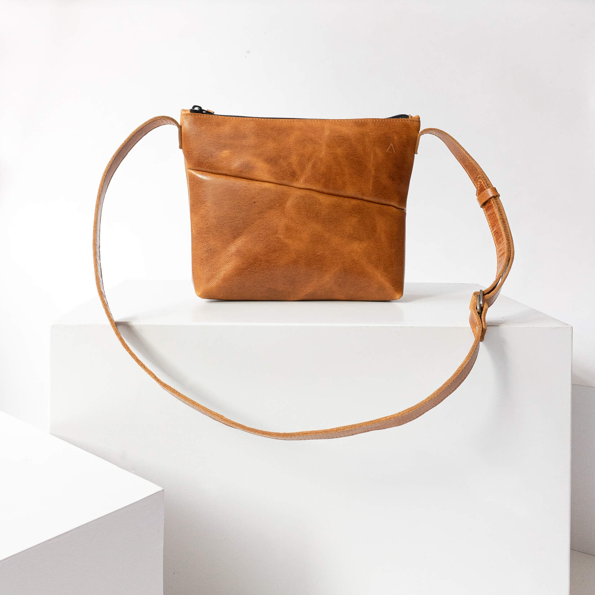 Umhängetasche IDA aus Naturleder in Cognac geölt auf Block stehend von vorn