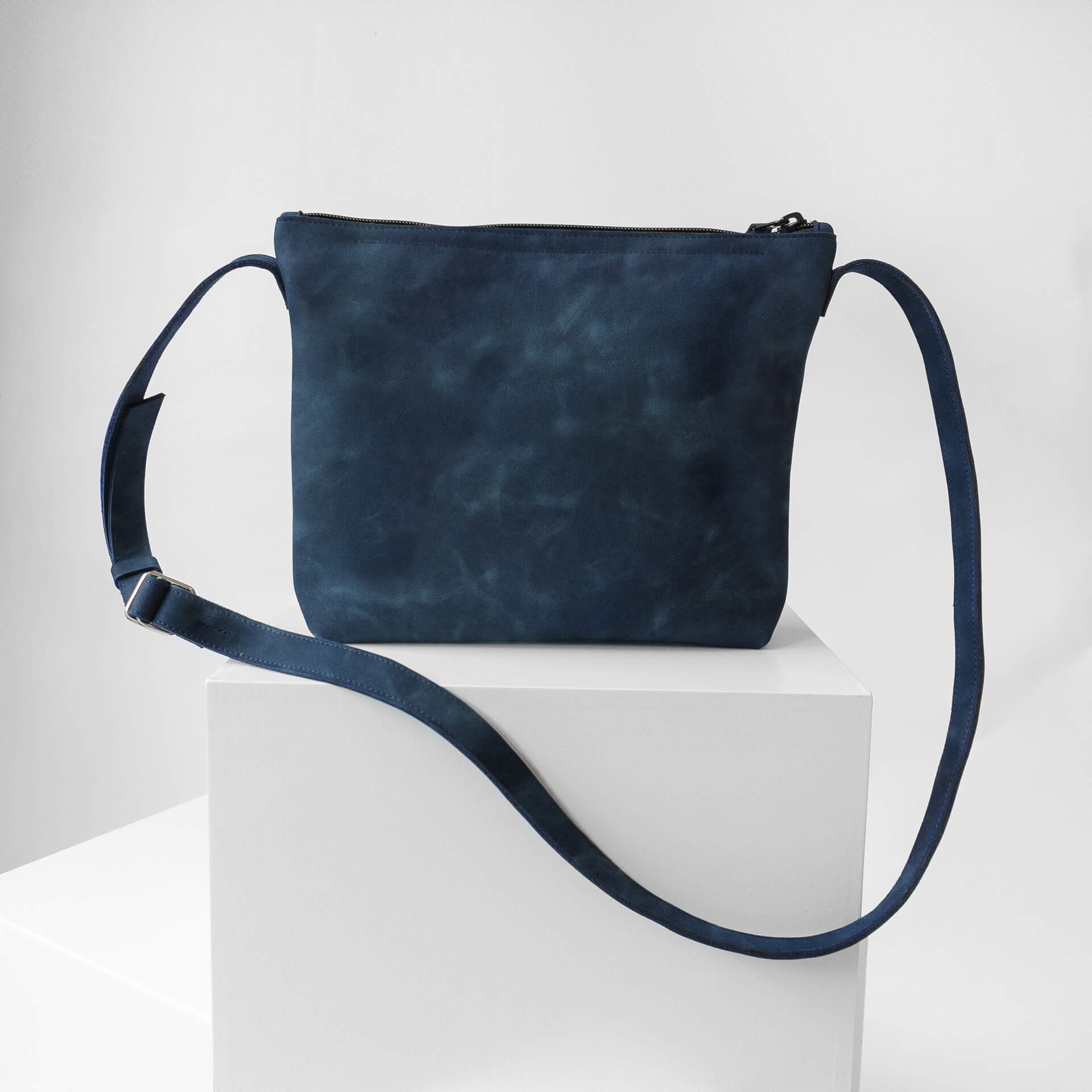 Umhängetasche IDA aus Naturleder in Dunkelblau auf Block stehend Rückseite