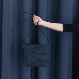 Umhängetasche IDA aus nachhaltigem Naturleder in Dunkelblau von vorn vor dunkelblauem Vorhang