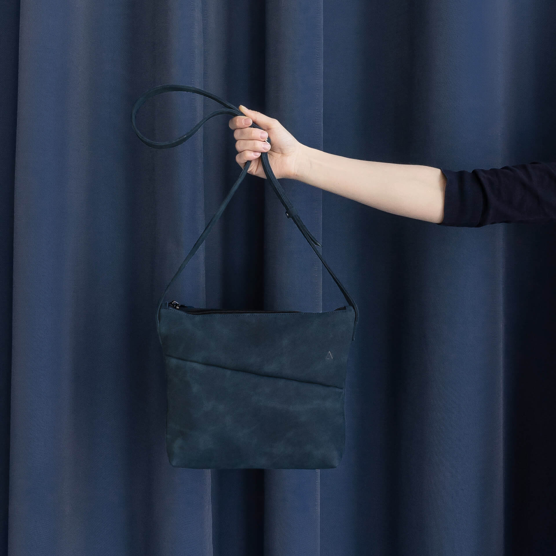 Umhängetasche IDA aus nachhaltigem Naturleder in Dunkelblau von vorn vor dunkelblauem Vorhang