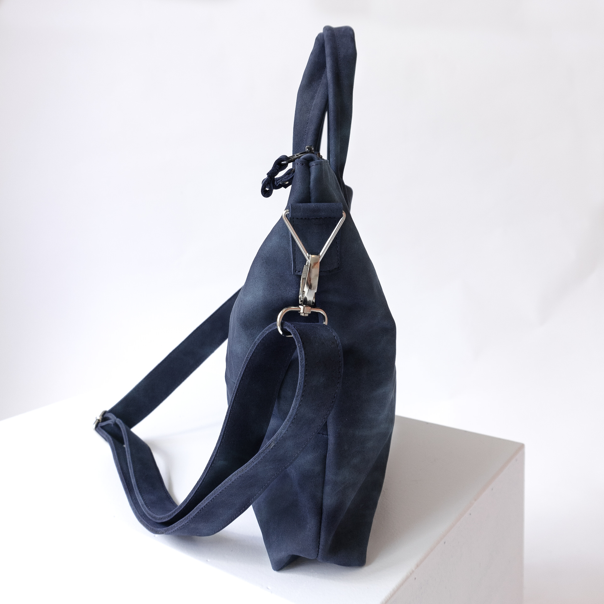 Seitenansicht Umhängetasche ANA mit Henkeln und Schultergurt aus dunkelblauem Naturleder